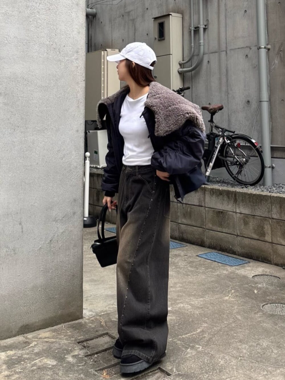 ブラック系のデニムパンツを着用したレディースの冬コーディネートの2枚目の写真