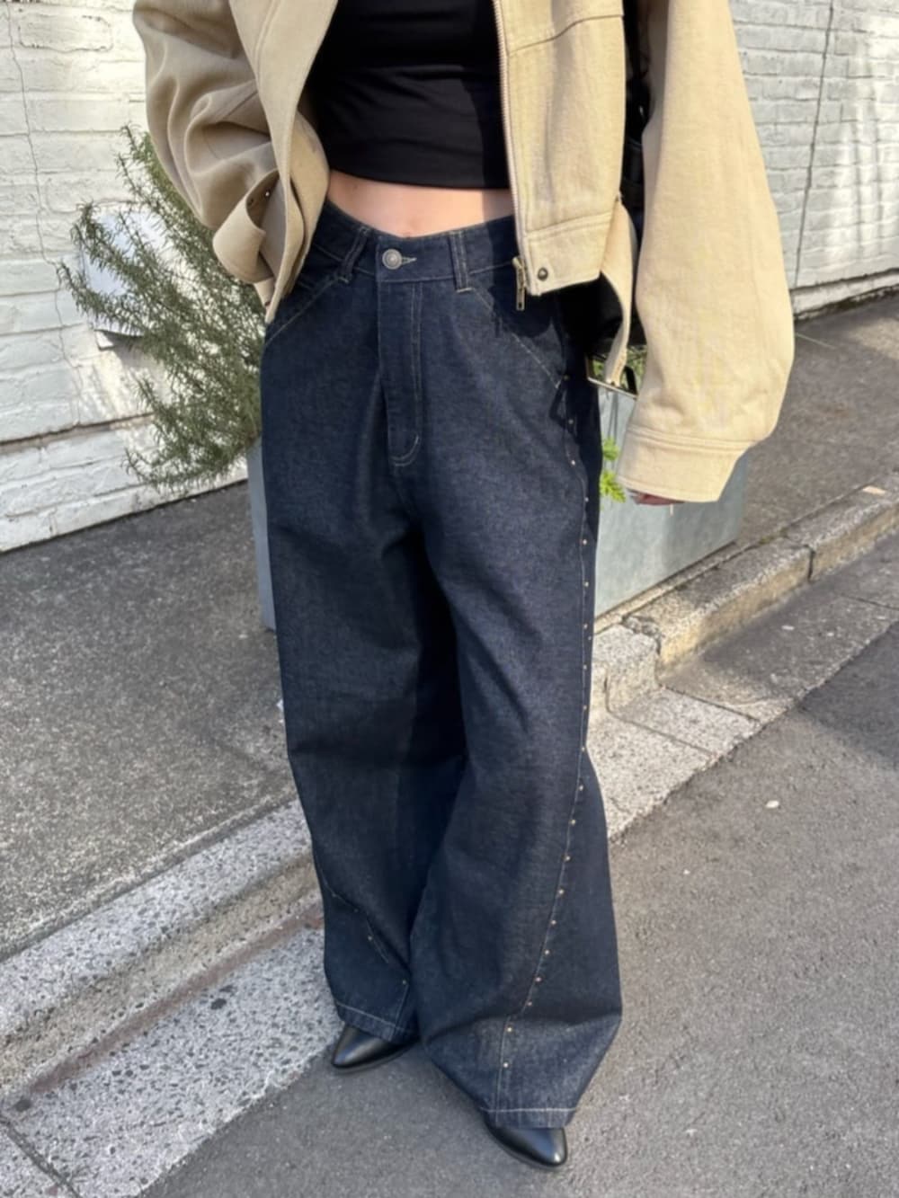 ブルー系のデニムパンツ、ブラック系のキャミソール、ベージュ系のその他アウターを着用したレディースの冬コーディネートの3枚目の写真