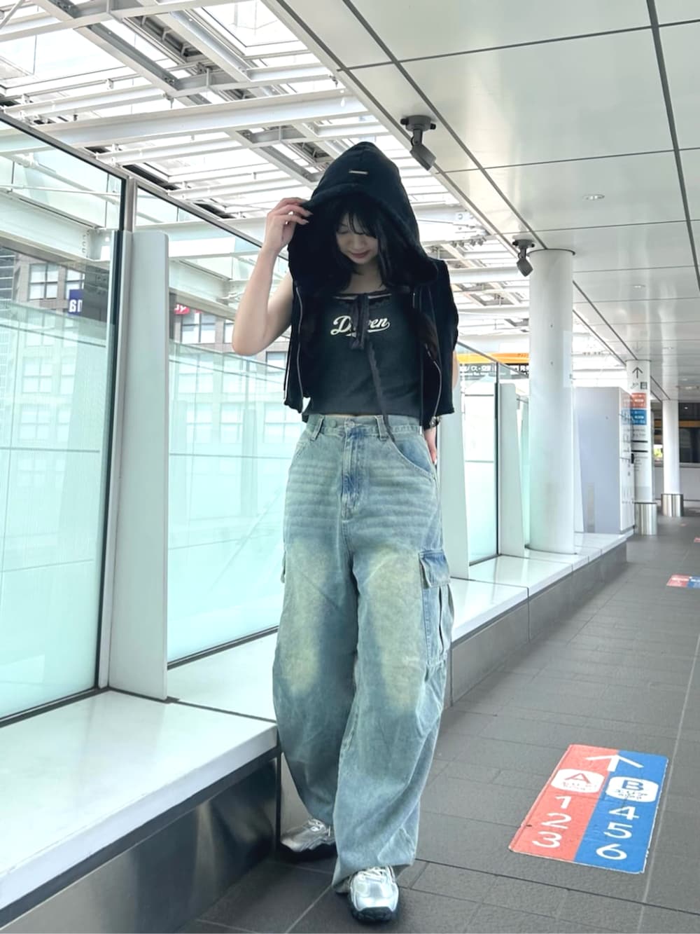 グレー系のキャミソール、ブラック系のTシャツ/カットソー、ブルー系のデニムパンツを着用したレディースの夏コーディネートの2枚目の写真