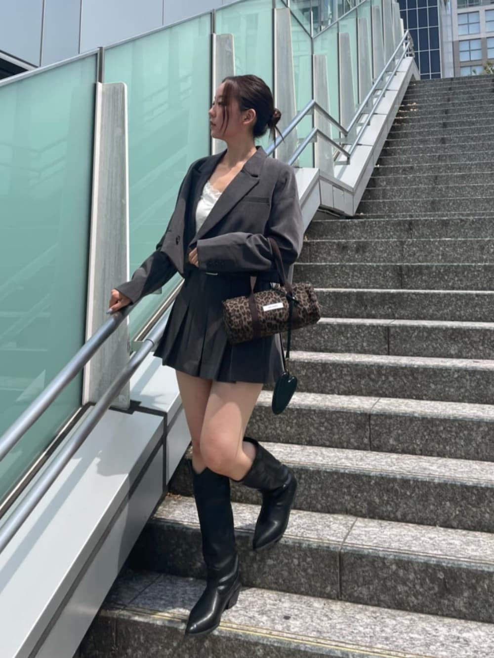 ホワイト系のキャミソール、ブラック系のブーツ、グレー系のその他アウターを着用したレディースの秋コーディネートの2枚目の写真