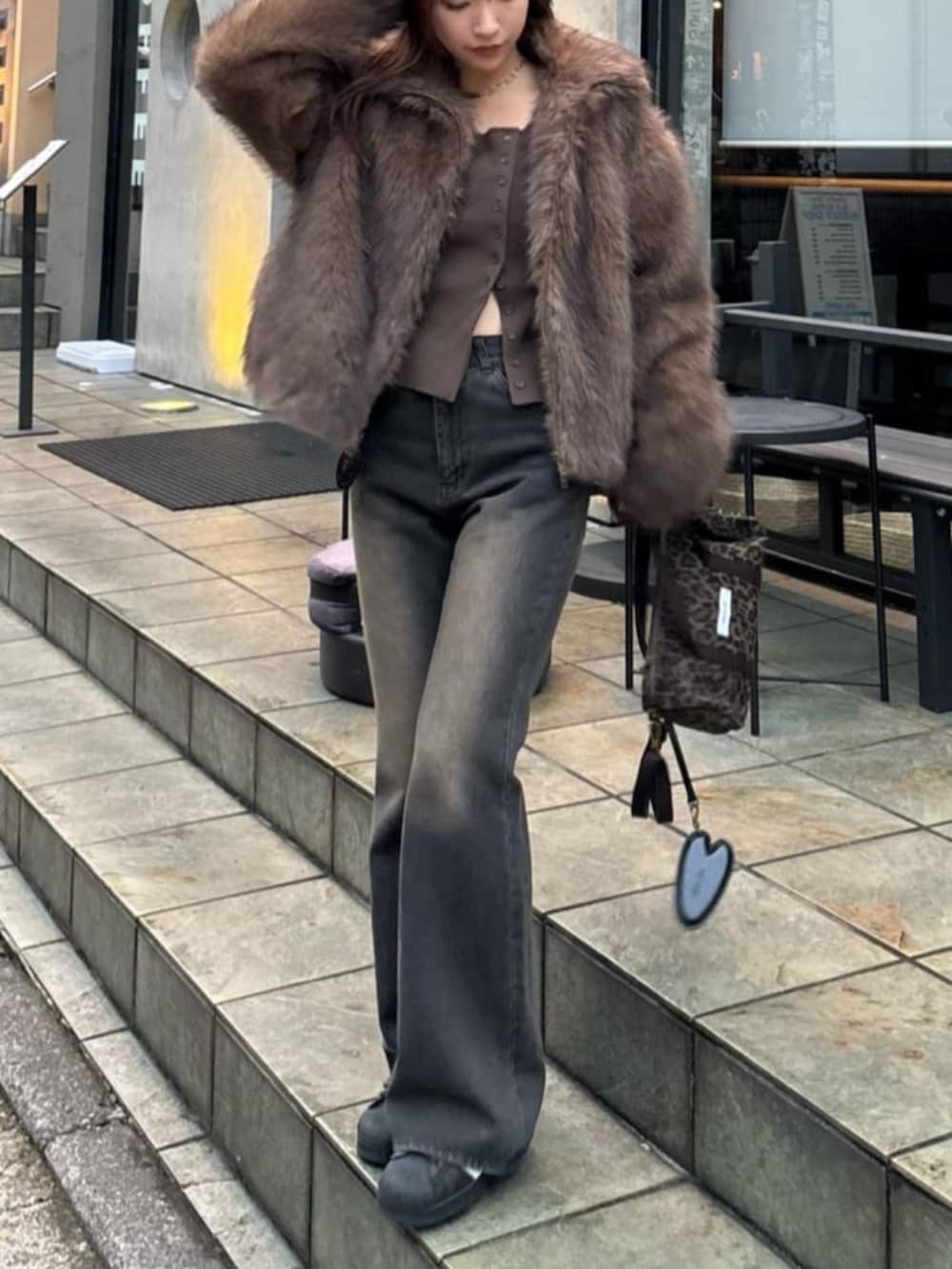 ブラウン系のデニムパンツ、ブラウン系のニット/セーター、ベージュ系のブルゾンを着用したレディースの秋コーディネートの3枚目の写真