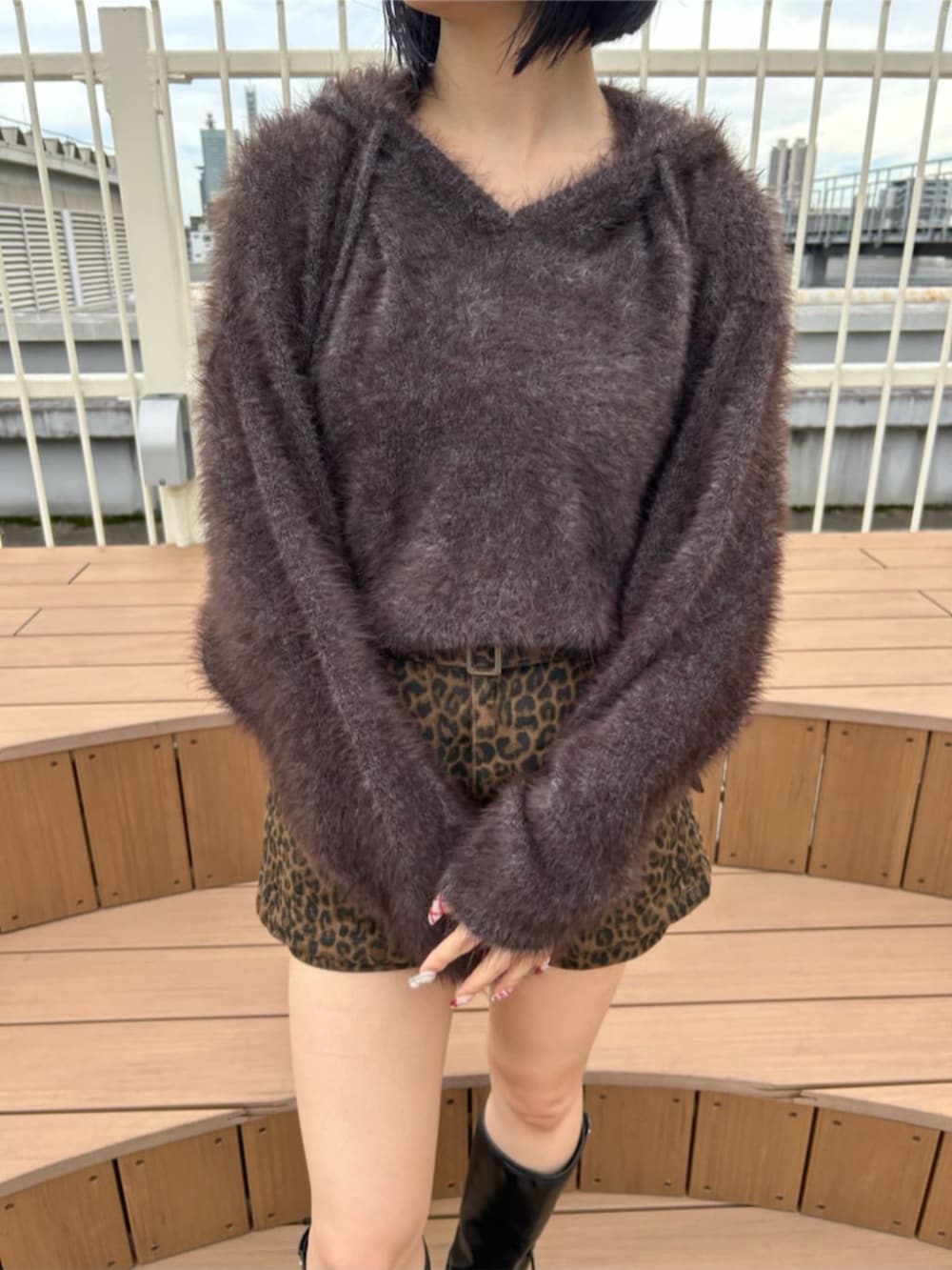 ブラック系のブーツ、ブラウン系のスカート、ブラウン系のニット/セーターを着用したレディースの秋コーディネートの2枚目の写真