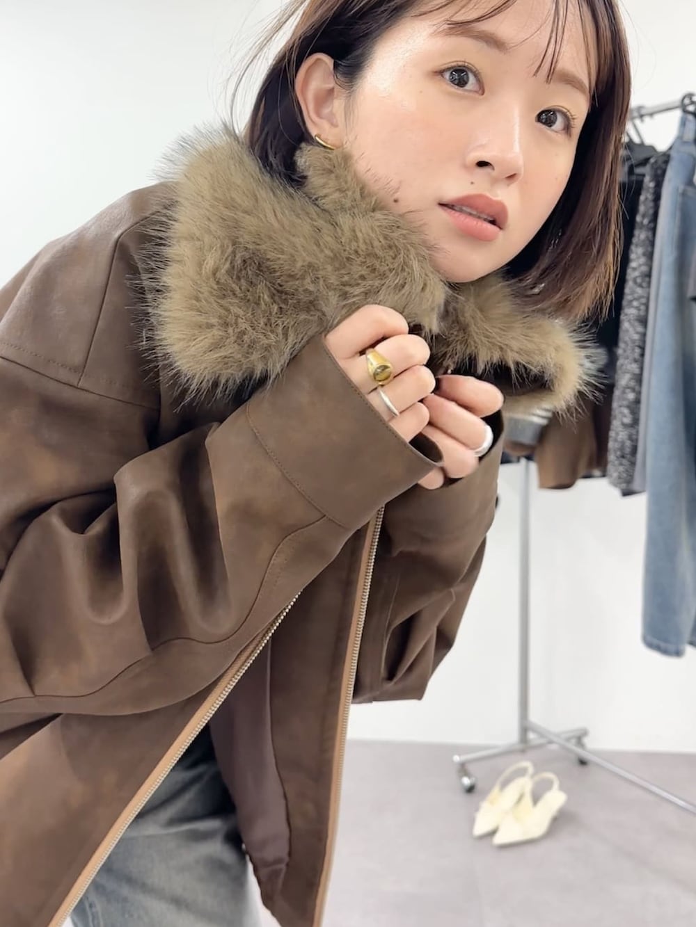 ベージュ系のブルゾン、ブルー系のデニムパンツを着用したレディースの秋コーディネートの2枚目の写真