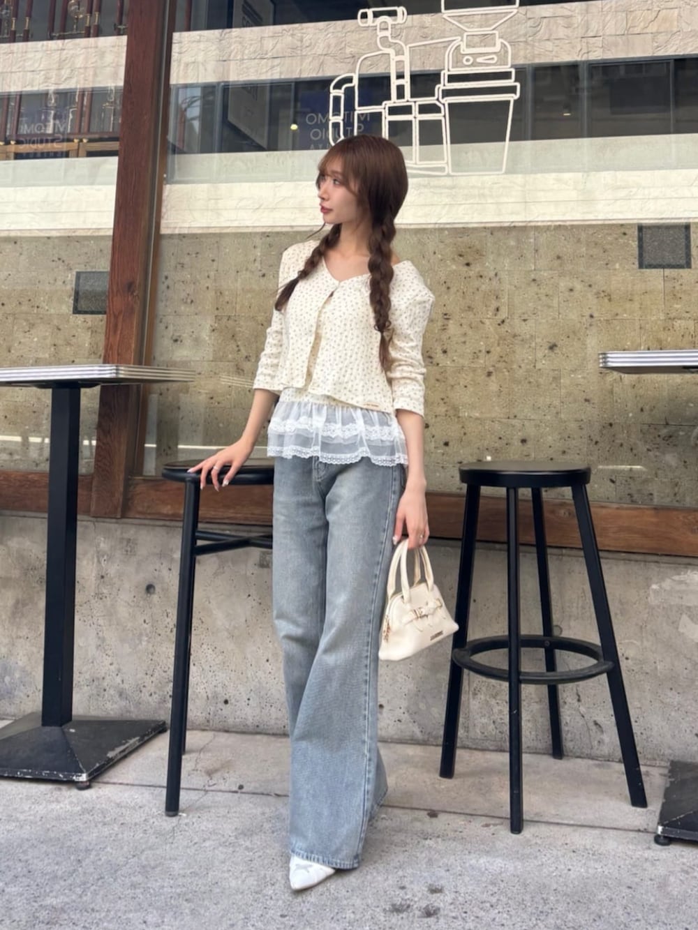 ブルー系のデニムパンツ、ホワイト系のサンダル、ホワイト系のカーディガン/ボレロを着用したレディースの春コーディネートの2枚目の写真