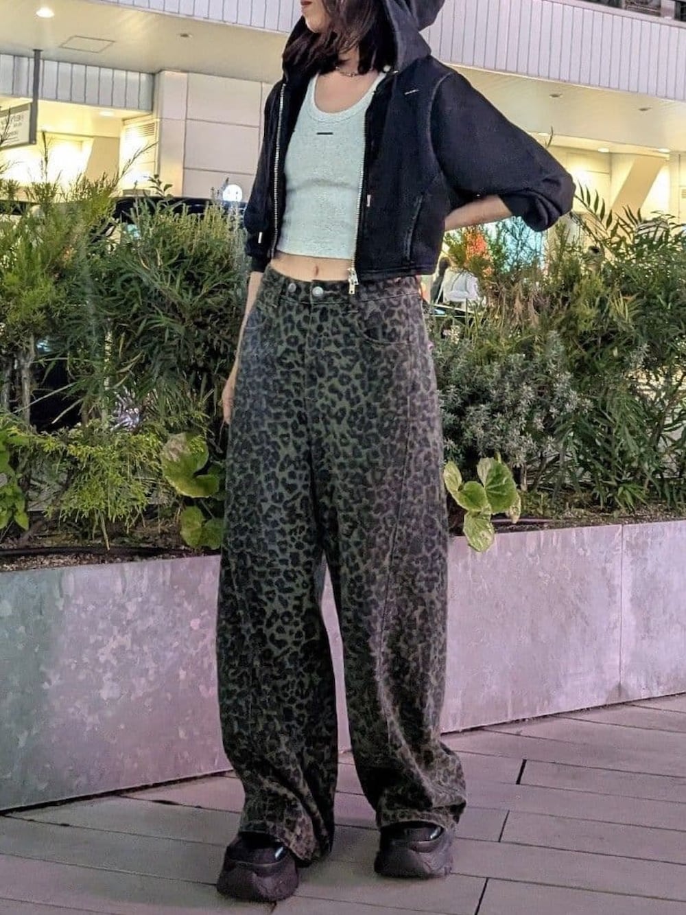 グリーン系のデニムパンツ、グレー系のタンクトップ、ブラック系のパーカーを着用したレディースの夏コーディネートの2枚目の写真