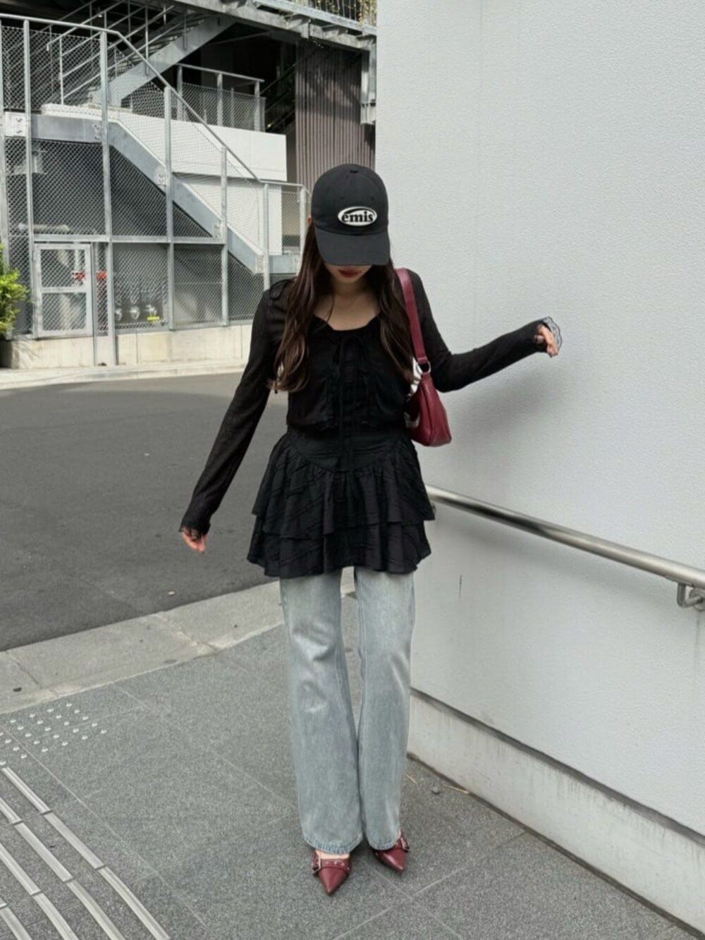 ブルー系のデニムパンツ、ブラック系のパーカー、ブラック系のワンピースを着用したレディースの春コーディネートの5枚目の写真