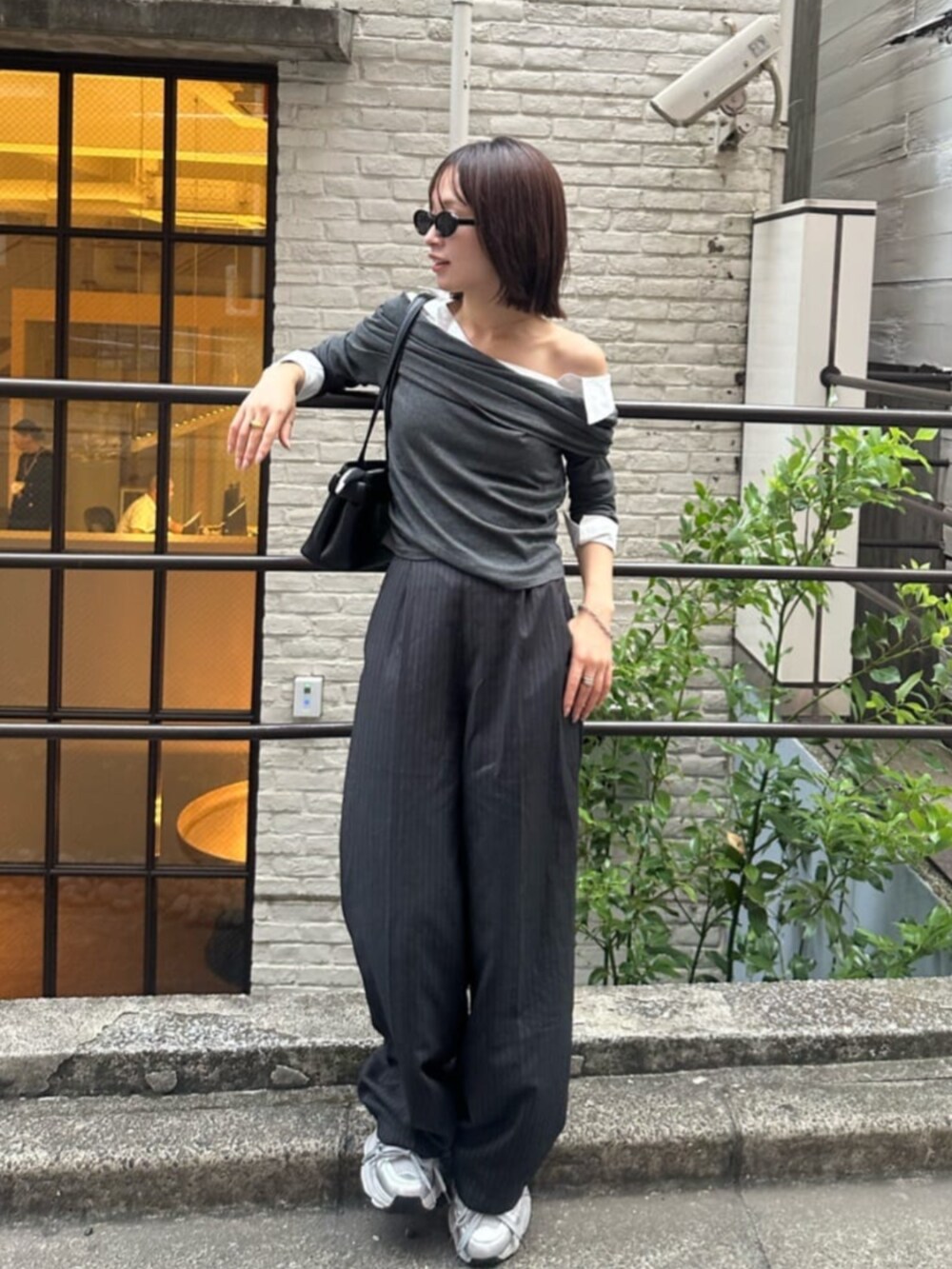 ブラック系のショルダーバッグ、グレー系のTシャツ/カットソーを着用したレディースの秋コーディネートの2枚目の写真