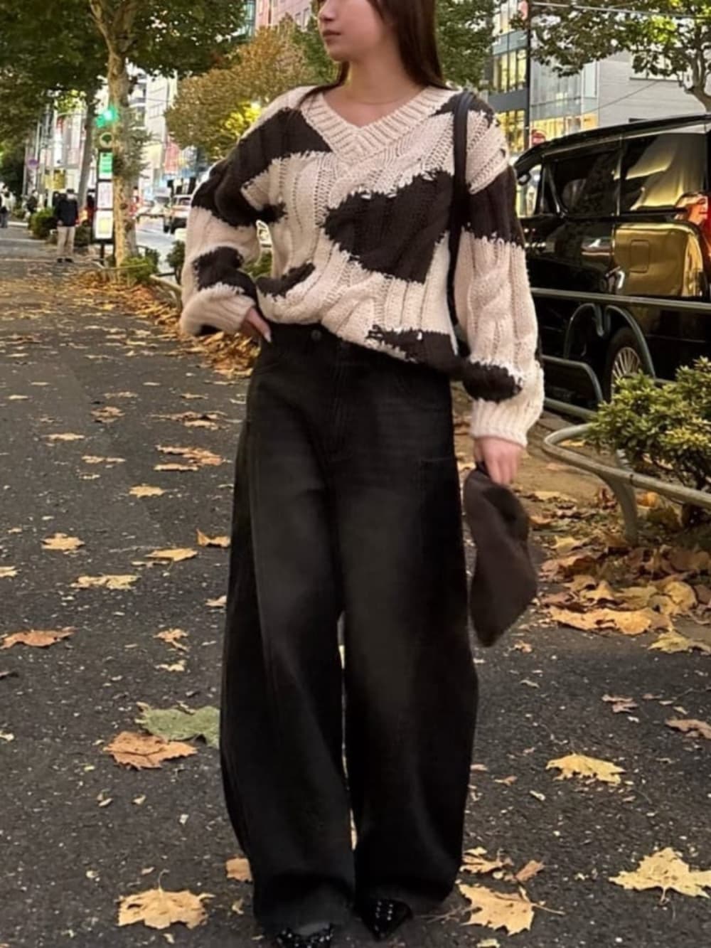 ブラック系のデニムパンツ、ホワイト系のニット/セーター、ブラック系のデニムパンツを着用したレディースの冬コーディネートの2枚目の写真