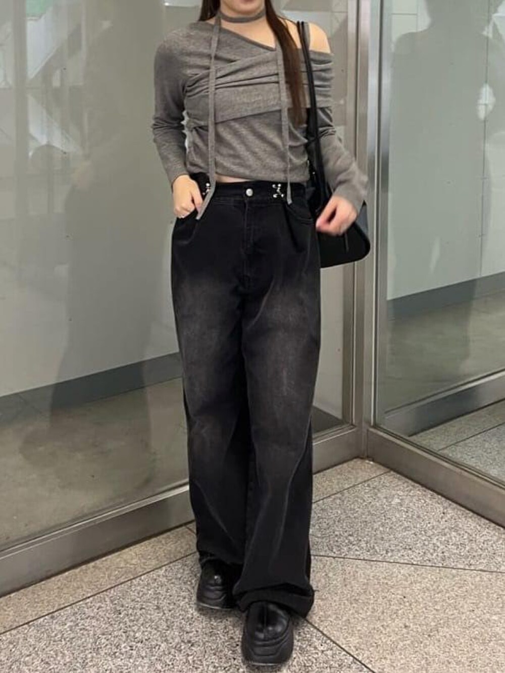 グレー系のニット/セーター、ブラック系のデニムパンツを着用したレディースの秋コーディネートの2枚目の写真