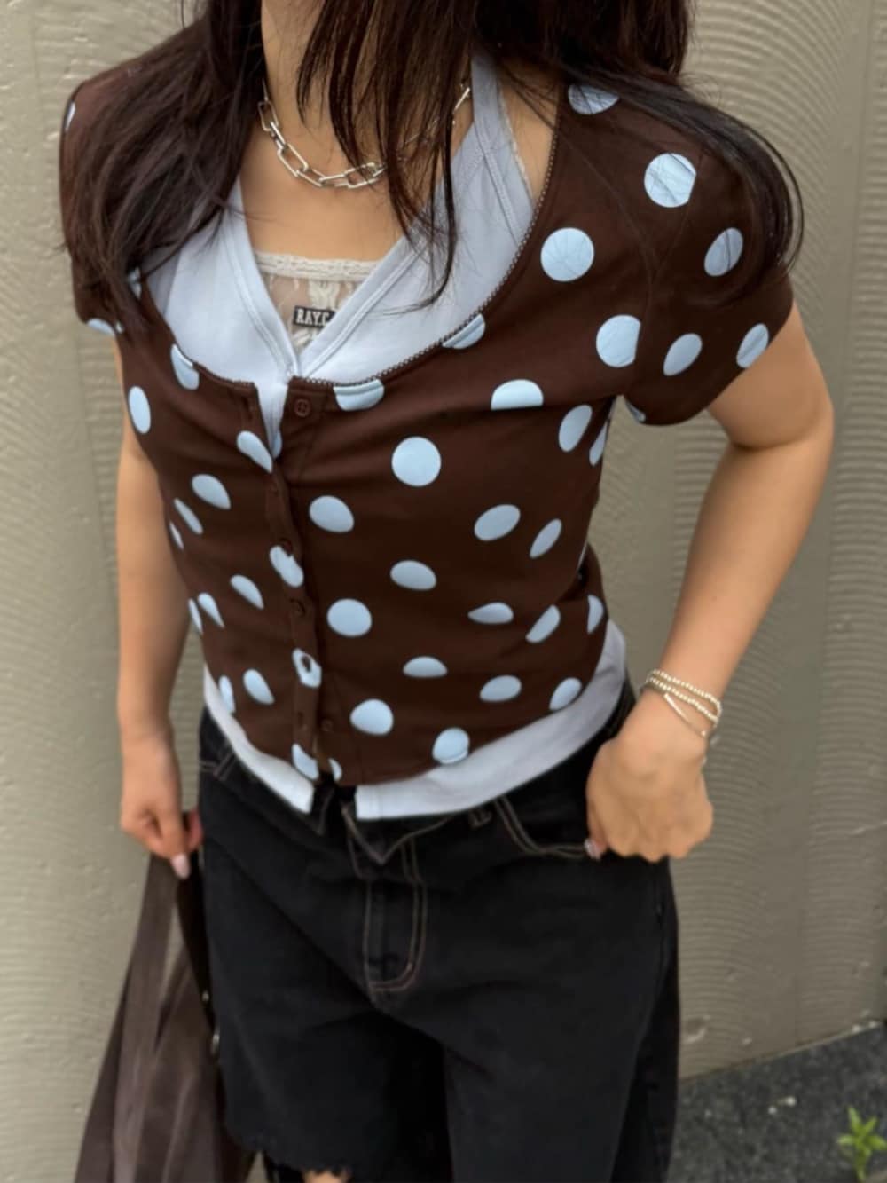 ブラック系のデニムパンツ、ブラウン系のトートバッグ、ブラウン系のTシャツ/カットソーを着用したレディースの夏コーディネートの2枚目の写真