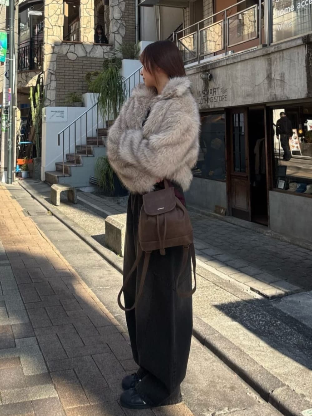 ブラック系のデニムパンツを着用したレディースの冬コーディネートの2枚目の写真