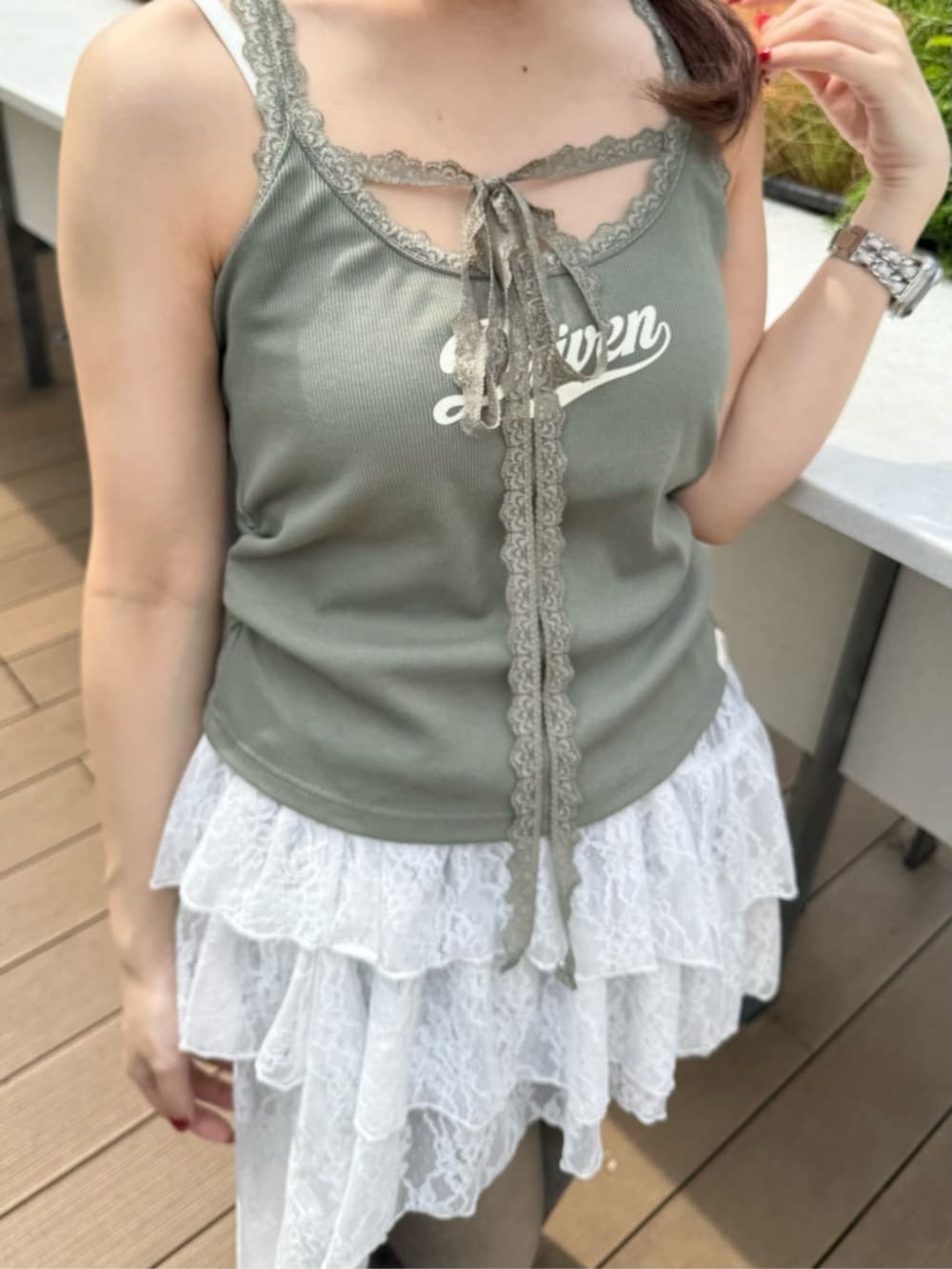 ホワイト系のサンダル、ホワイト系のスカート、グリーン系のキャミソールを着用したレディースの夏コーディネートの2枚目の写真