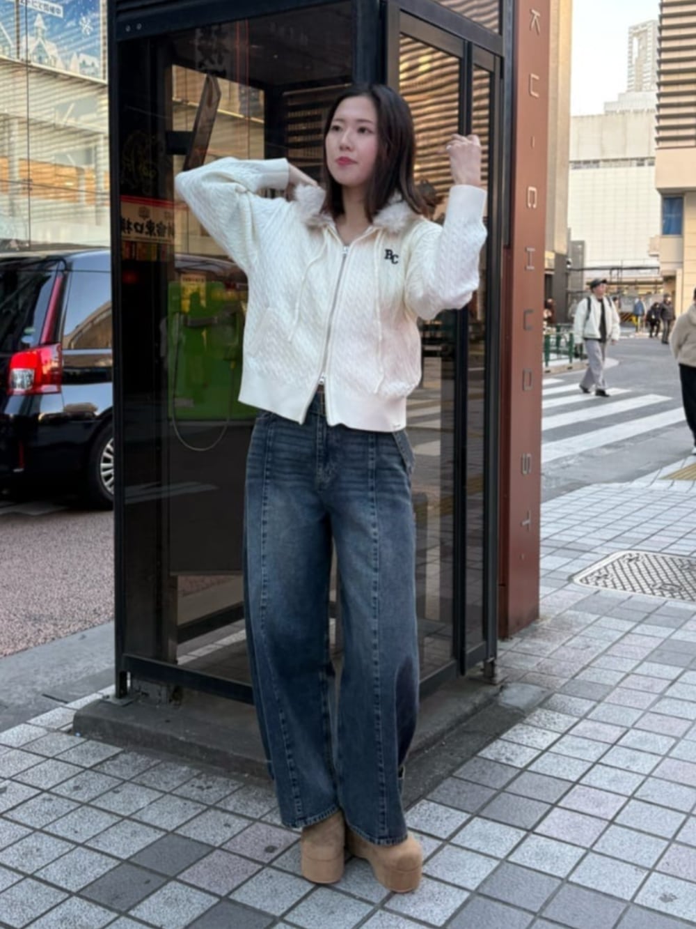 ベージュ系のパーカー、ベージュ系のスリッポン、ブルー系のデニムパンツを着用したレディースの冬コーディネートの2枚目の写真