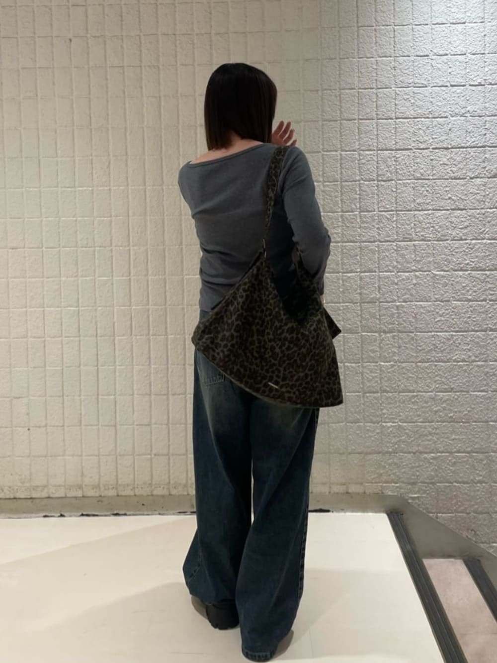 ブルー系のデニムパンツ、ブラック系のブルゾン、ブラック系のその他シューズを着用したレディースの秋コーディネートの4枚目の写真