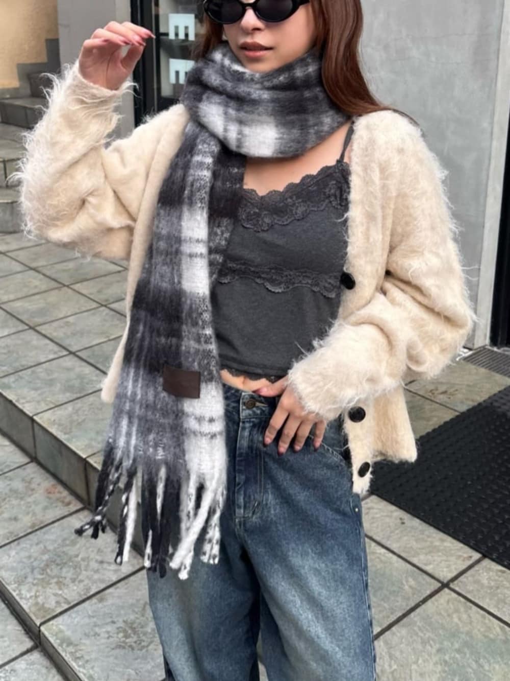 ベージュ系のカーディガン/ボレロ、ブルー系のデニムパンツ、グレー系のキャミソールを着用したレディースの秋コーディネートの2枚目の写真