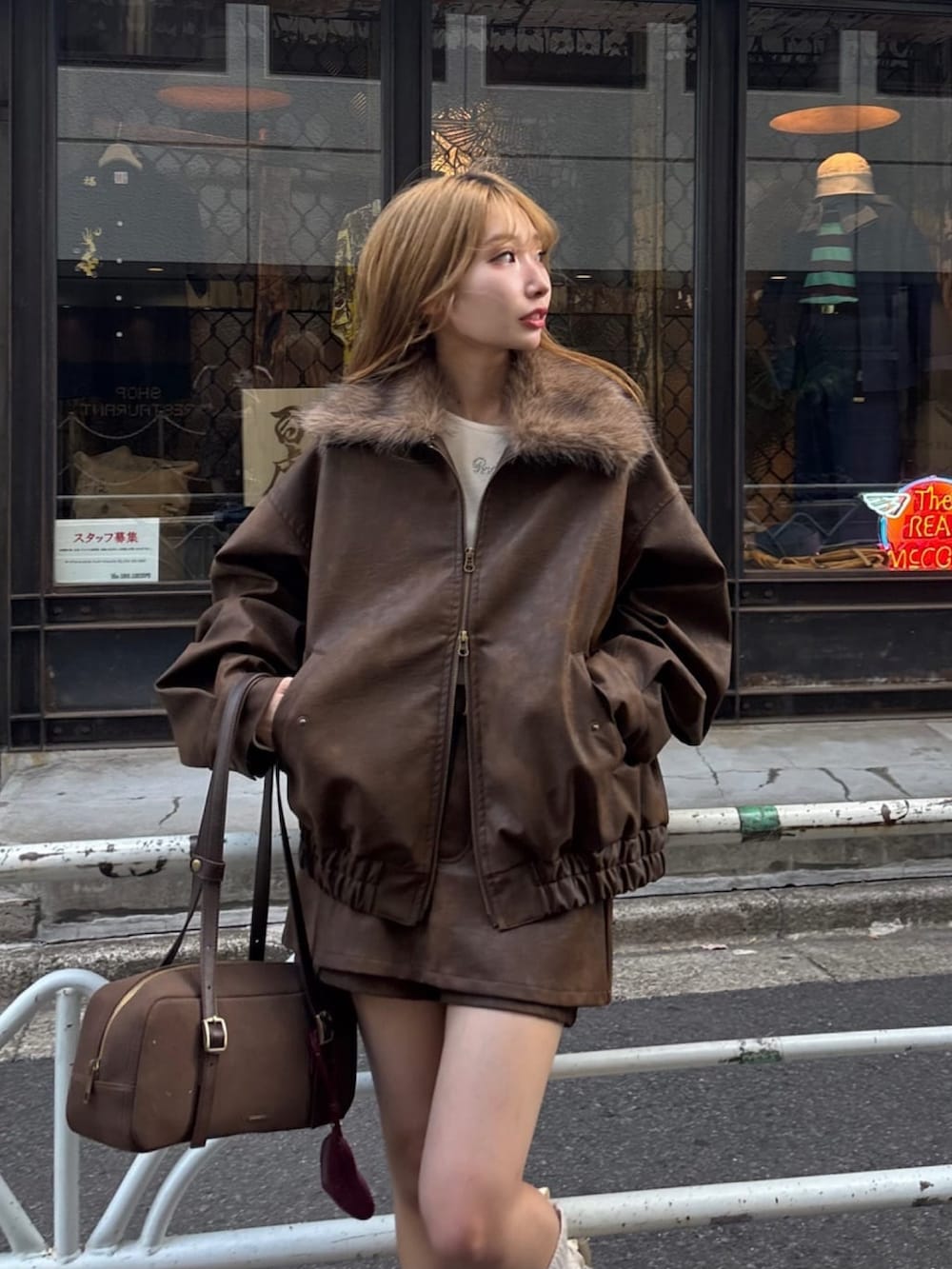 ベージュ系のスカート、ホワイト系のTシャツ/カットソー、ブラウン系のトートバッグを着用したレディースの秋コーディネートの2枚目の写真