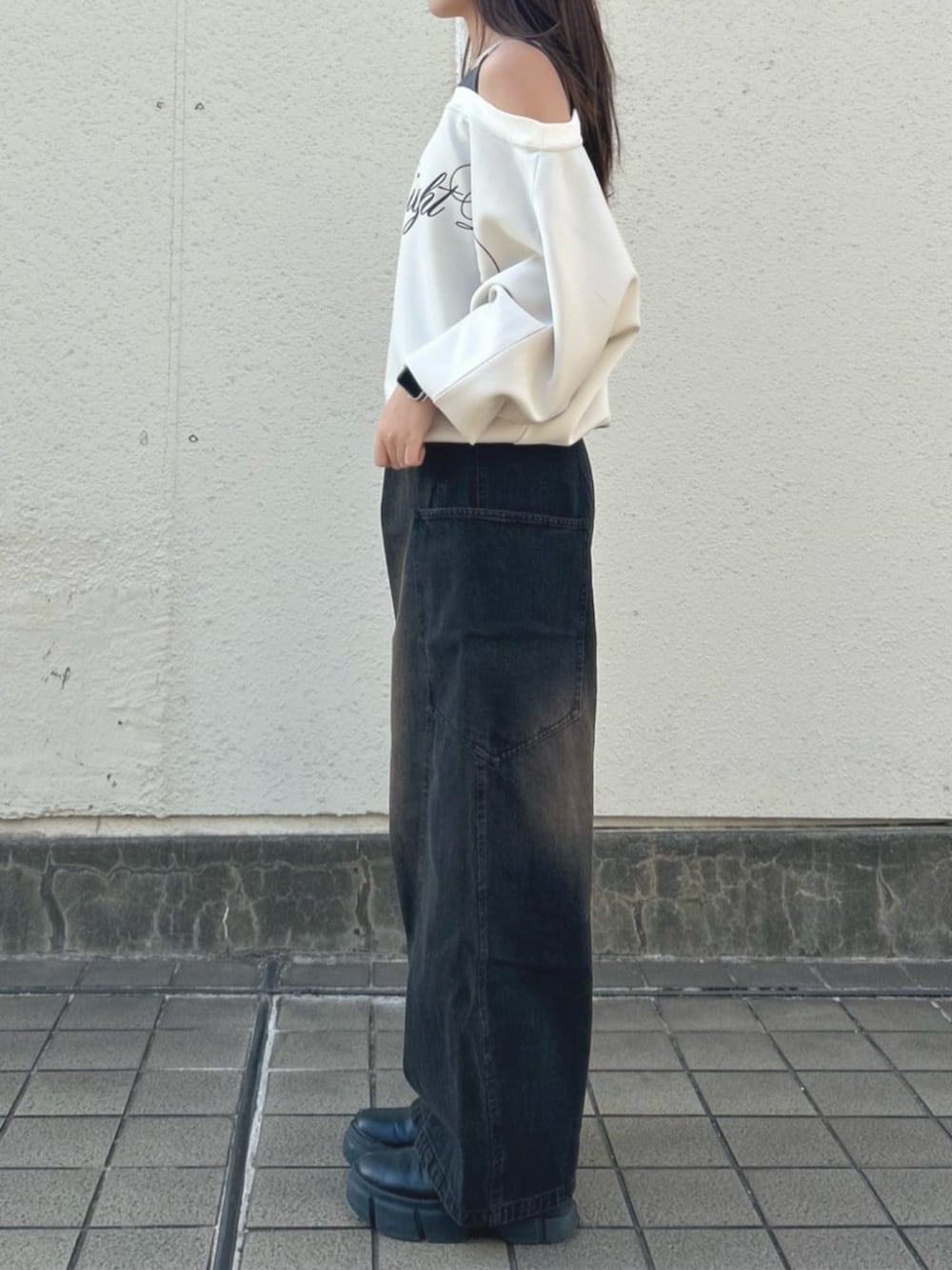 ベージュ系のスウェット、ブラック系のデニムパンツ、ブラック系のデニムパンツを着用したレディースの秋コーディネートの2枚目の写真