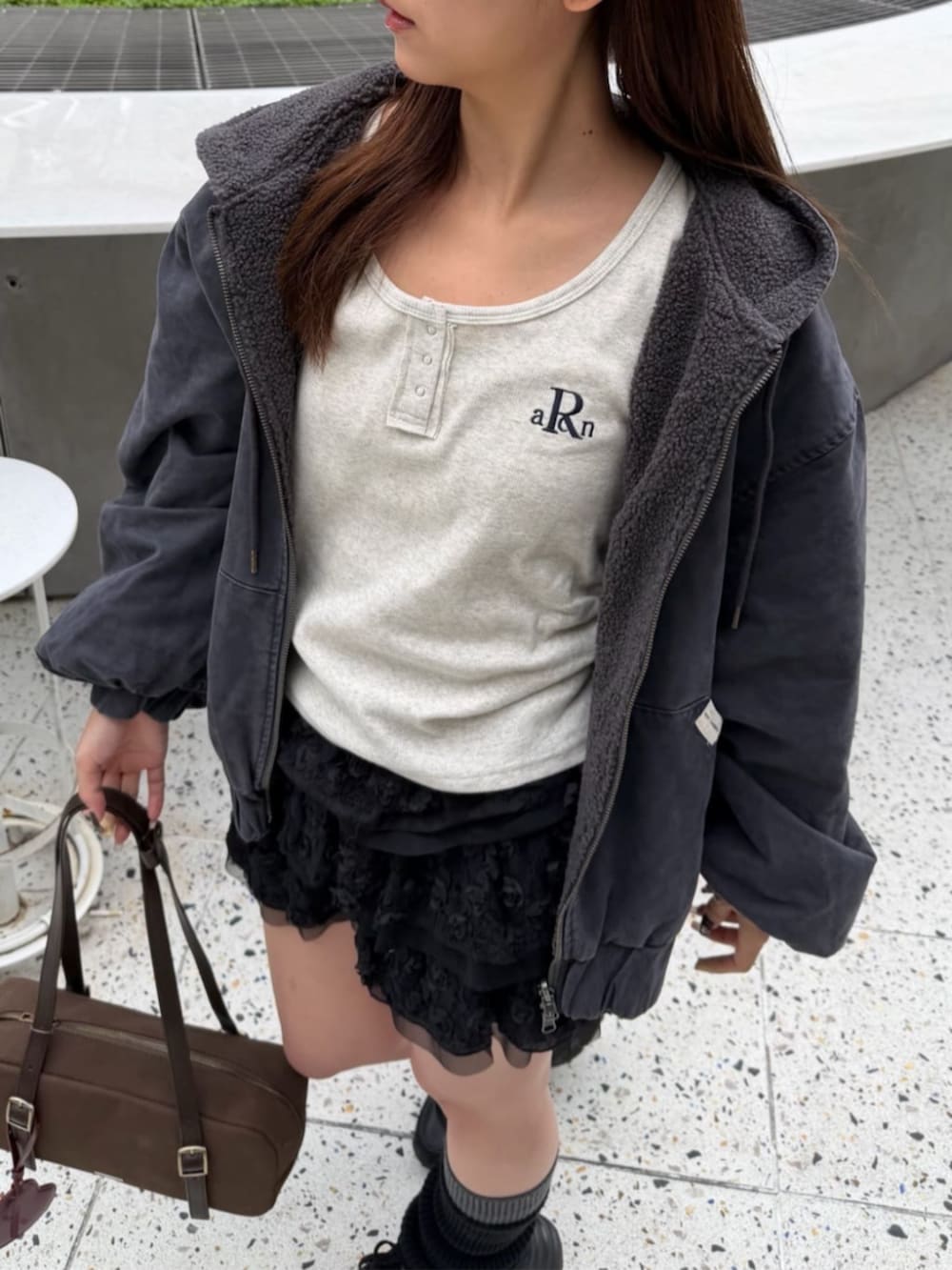 ブラック系のスカート、グレー系のブルゾン、ホワイト系のTシャツ/カットソーを着用したレディースの秋コーディネートの4枚目の写真