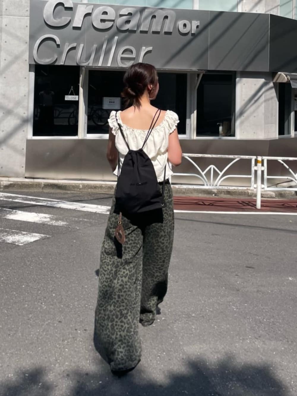 ブラック系のその他シューズ、ホワイト系のシャツ/ブラウス、グリーン系のデニムパンツを着用したレディースの秋コーディネートの2枚目の写真