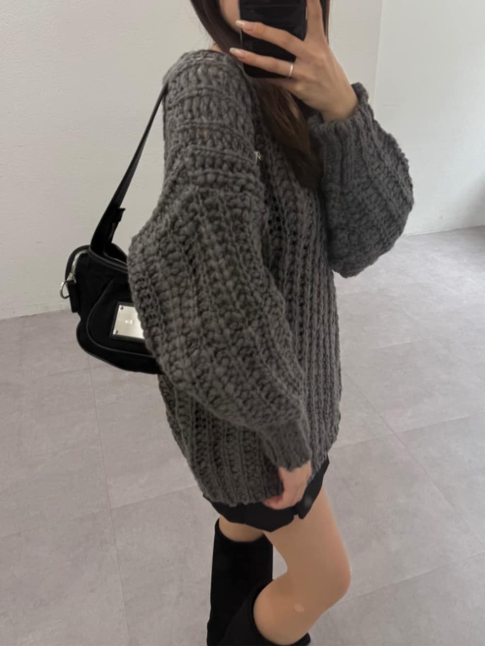 ブラック系のスカート、グレー系のニット/セーターを着用したレディースの秋コーディネートの3枚目の写真