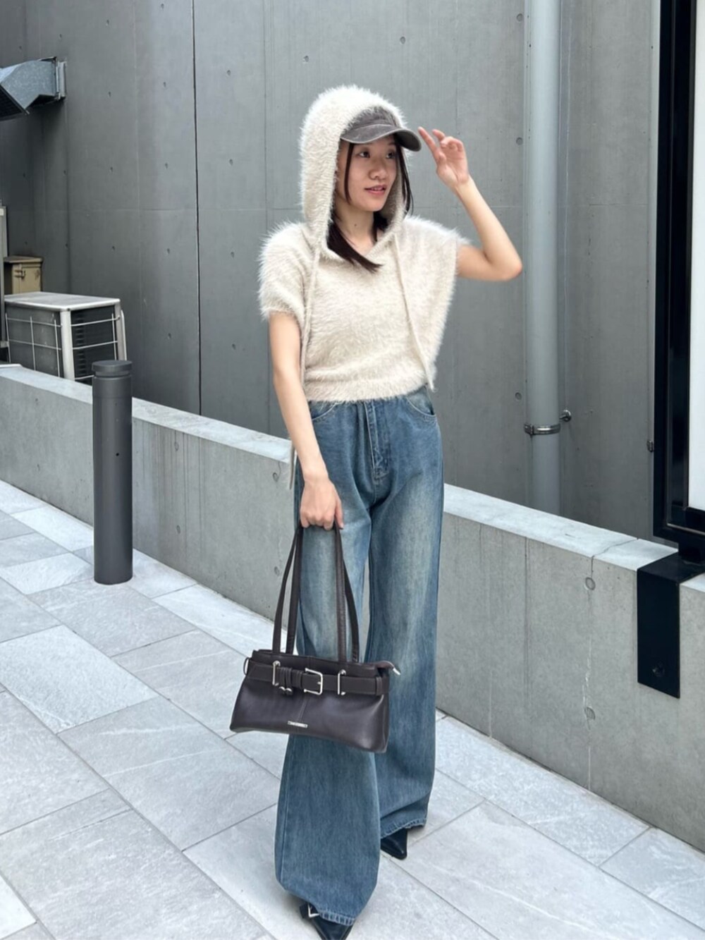 ブルー系のデニムパンツ、ベージュ系のニット/セーター、ブラウン系のキャップを着用したレディースの秋コーディネートの2枚目の写真