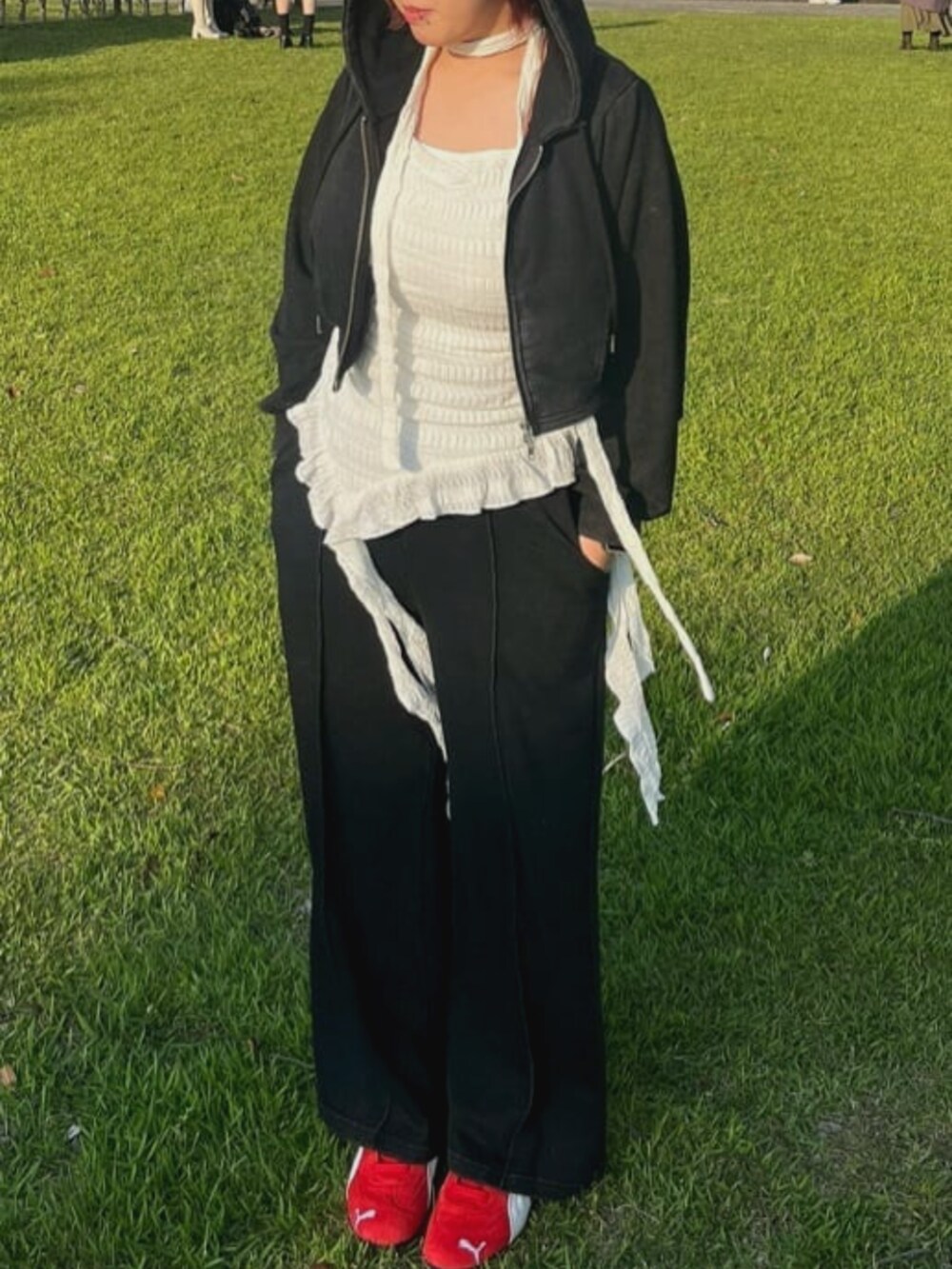 ブラック系のパーカー、ブラック系のスウェットパンツ、ホワイト系のキャミソールを着用したレディースの夏コーディネートの2枚目の写真