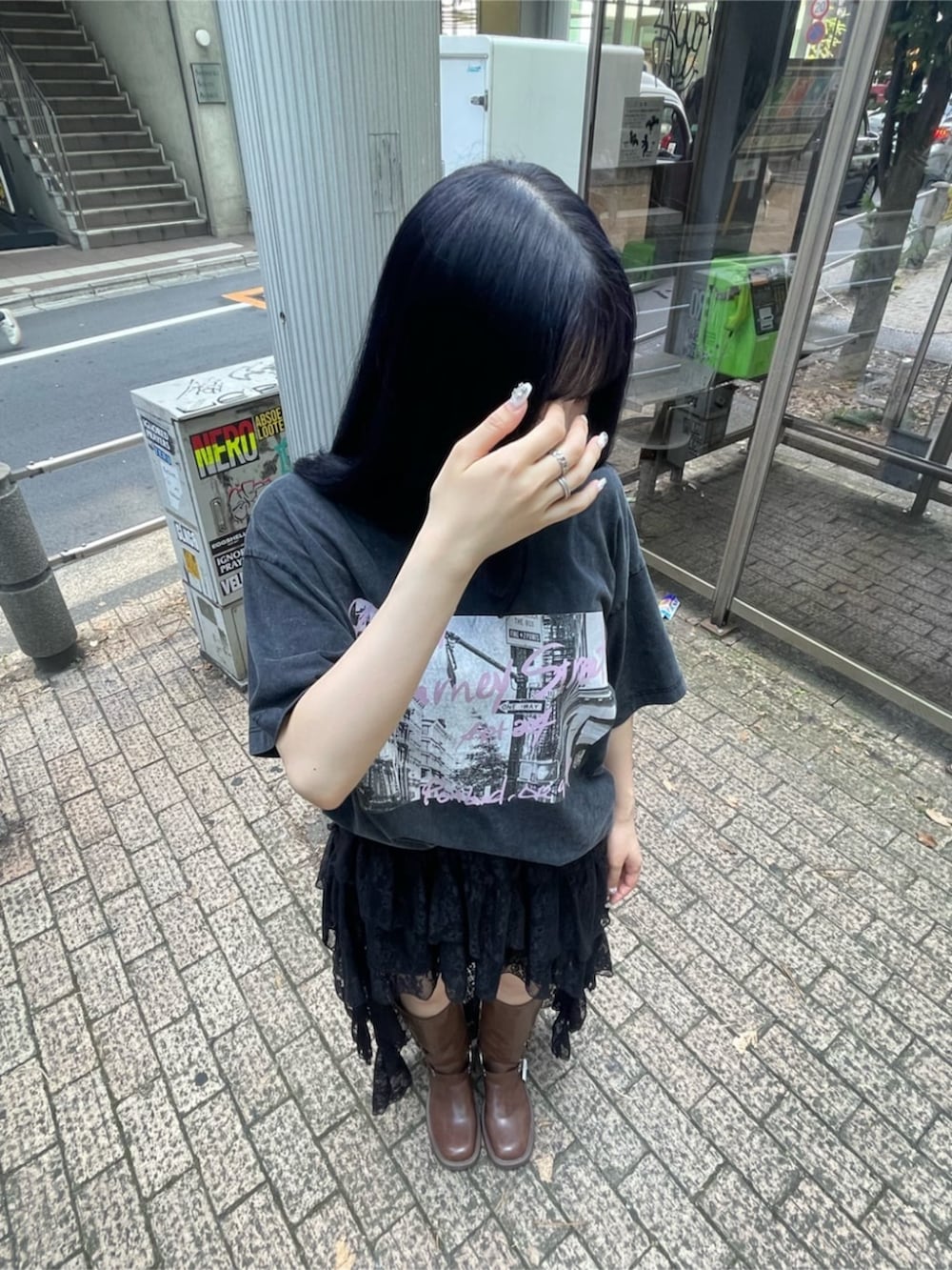 ブラック系のTシャツ/カットソー、ブラック系のスカート、ブラウン系のブーツを着用したレディースの夏コーディネートの3枚目の写真