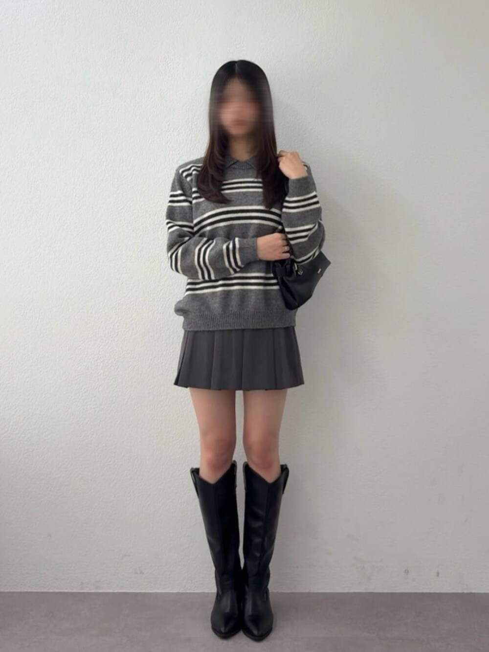 グレー系のニット/セーター、ブラック系のブーツを着用したレディースの秋コーディネートの2枚目の写真