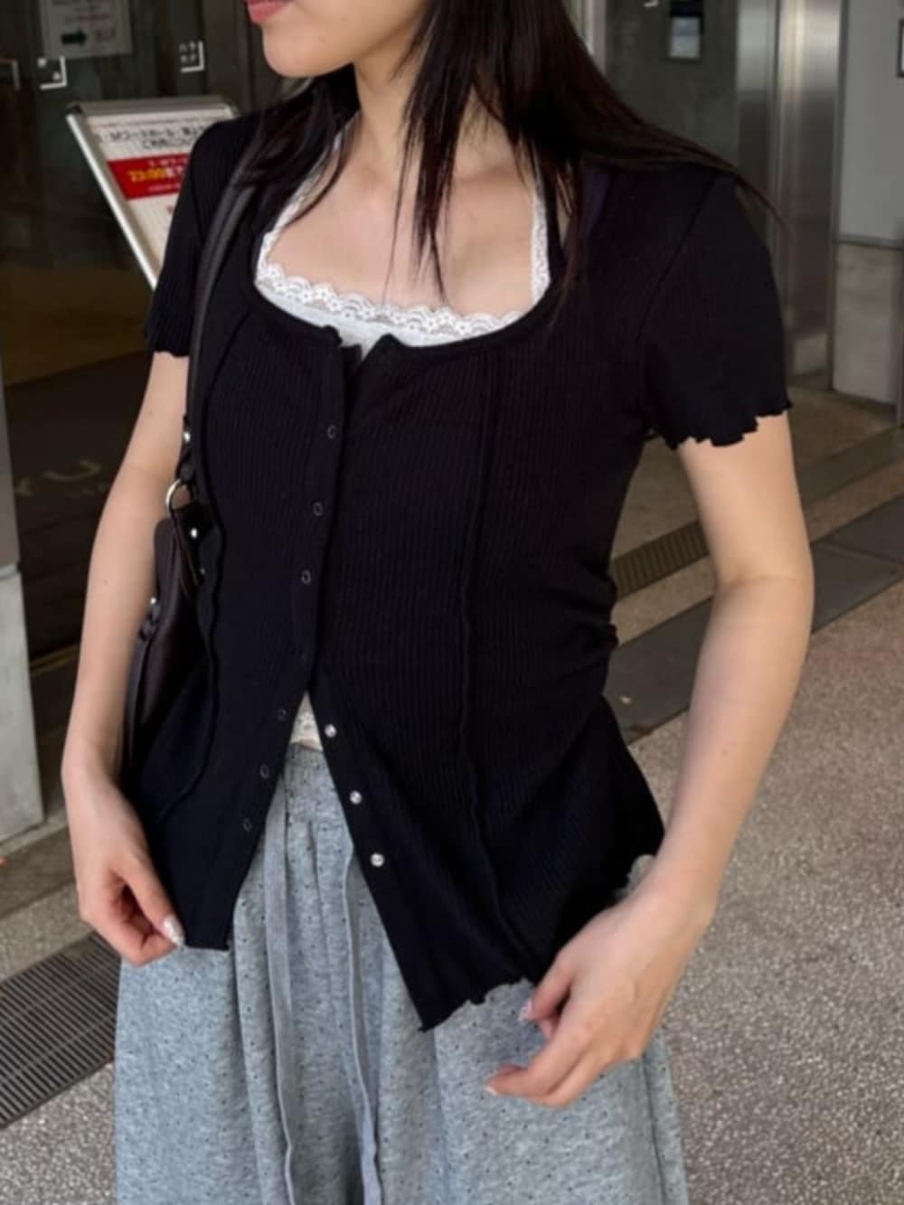 グレー系のスウェットパンツ、シルバー系のスニーカー、ブラック系のTシャツ/カットソーを着用したレディースの春コーディネートの2枚目の写真