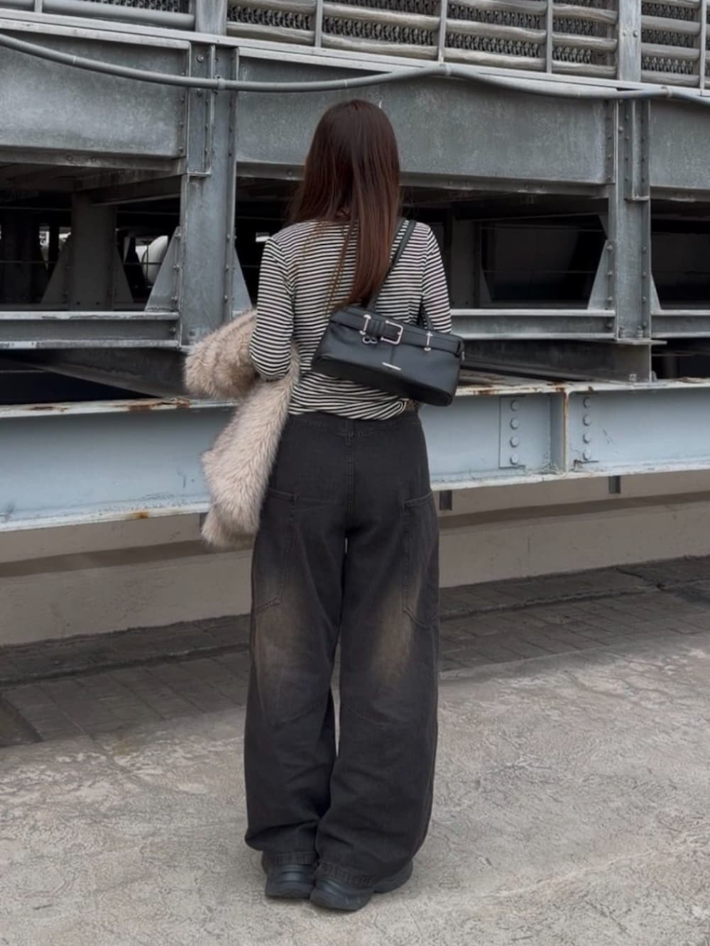 ブラック系のデニムパンツ、ホワイト系のTシャツ/カットソー、ブラック系のデニムパンツを着用したレディースの冬コーディネートの3枚目の写真