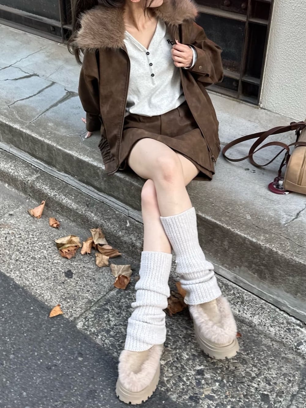 ベージュ系のスカート、ホワイト系のTシャツ/カットソー、ブラウン系のトートバッグを着用したレディースの秋コーディネートの4枚目の写真