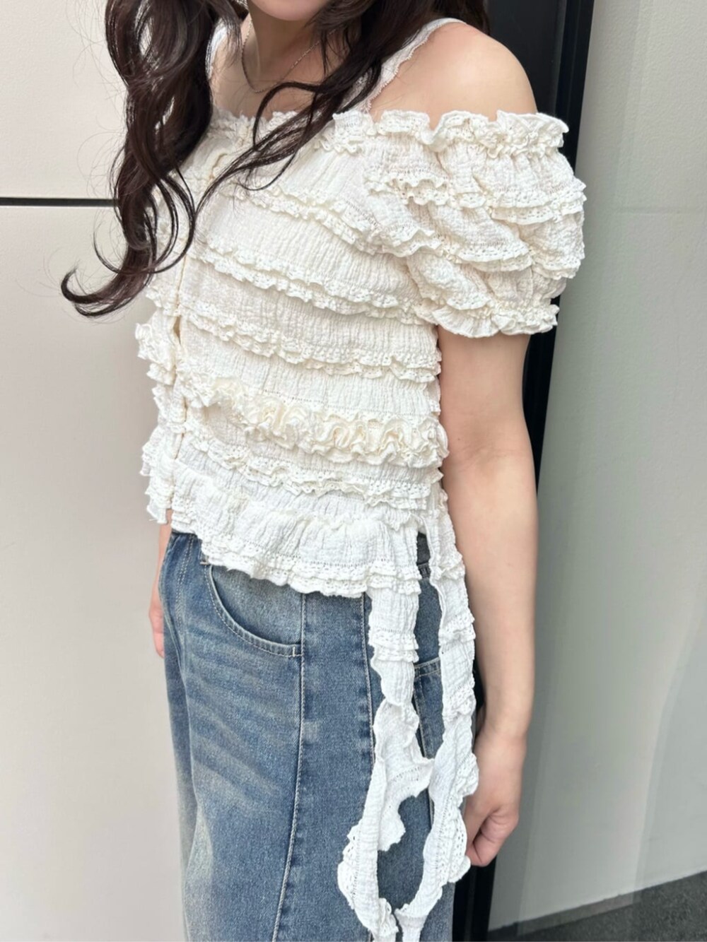 ホワイト系のサンダル、ホワイト系のTシャツ/カットソー、ブルー系のデニムパンツを着用したレディースの夏コーディネートの2枚目の写真