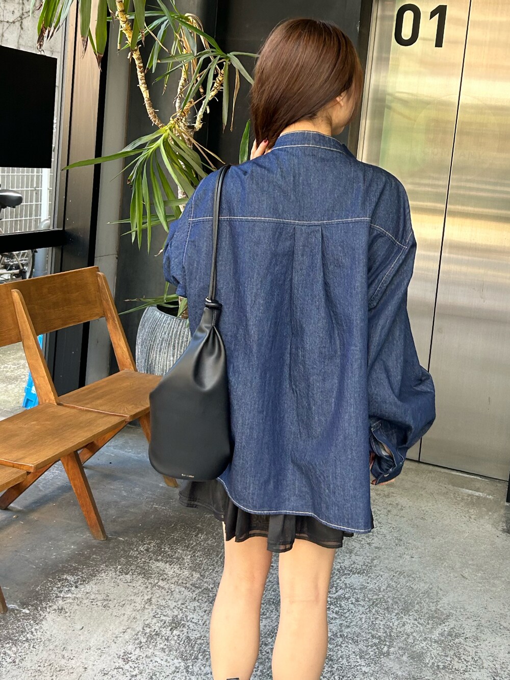 ブルー系のシャツ/ブラウス、ブラック系のスカートを着用したレディースの秋コーディネートの2枚目の写真