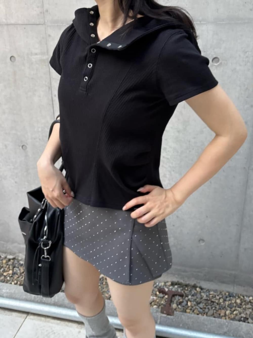 ブラック系のショルダーバッグ、ブラック系のTシャツ/カットソー、グレー系のスカートを着用したレディースの春コーディネートの2枚目の写真