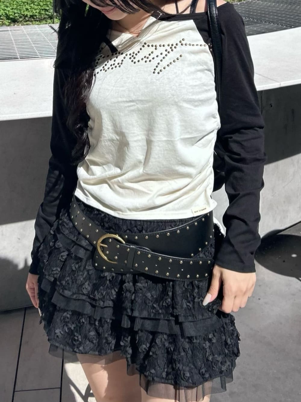 ブラック系のブーツ、ブラック系のスカート、ホワイト系のTシャツ/カットソーを着用したレディースの秋コーディネートの3枚目の写真