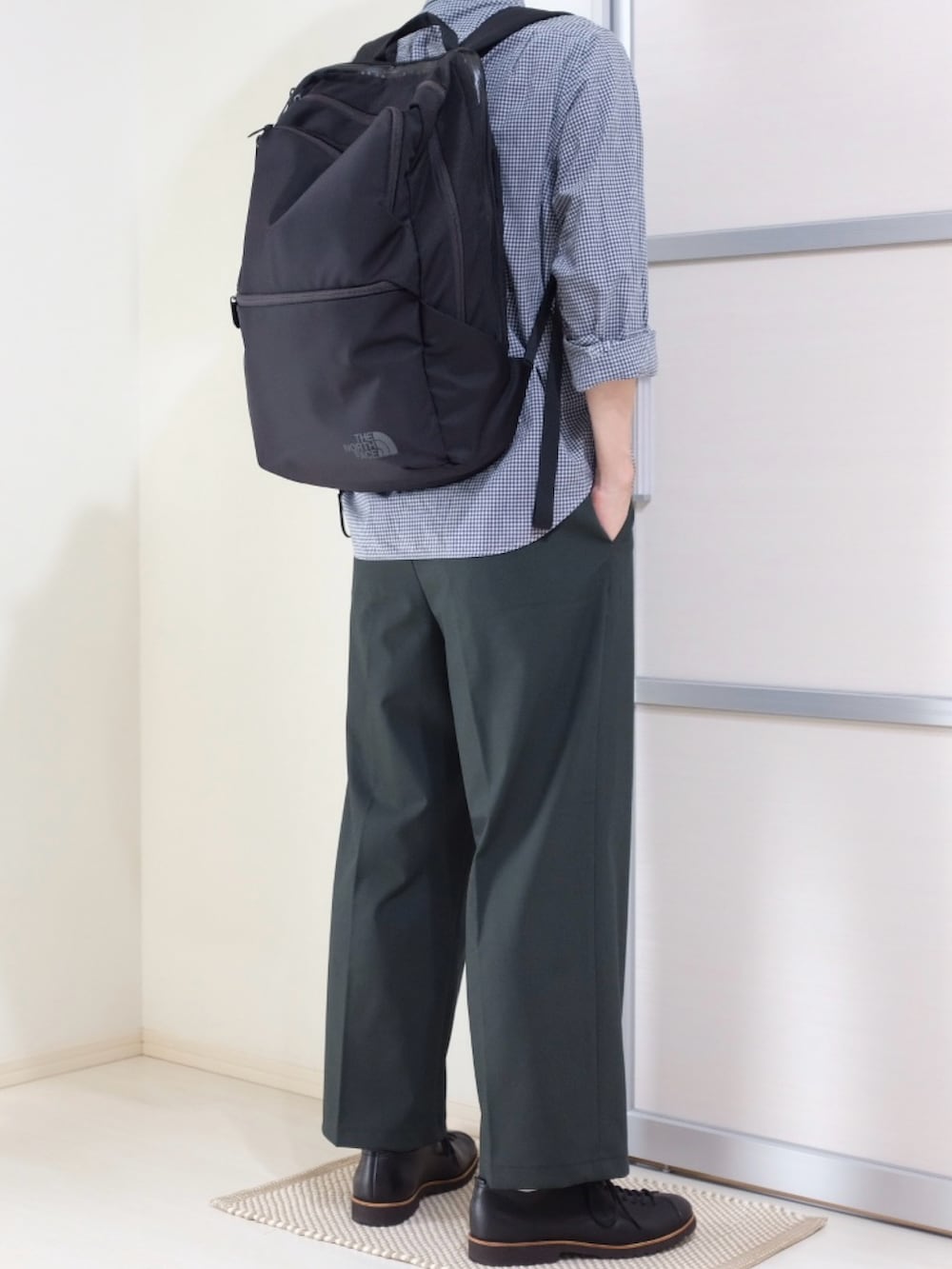 ブラック系のバックパック/リュック、グリーン系のパンツ、ブラック系のドレスシューズを着用したメンズの秋コーディネートの3枚目の写真