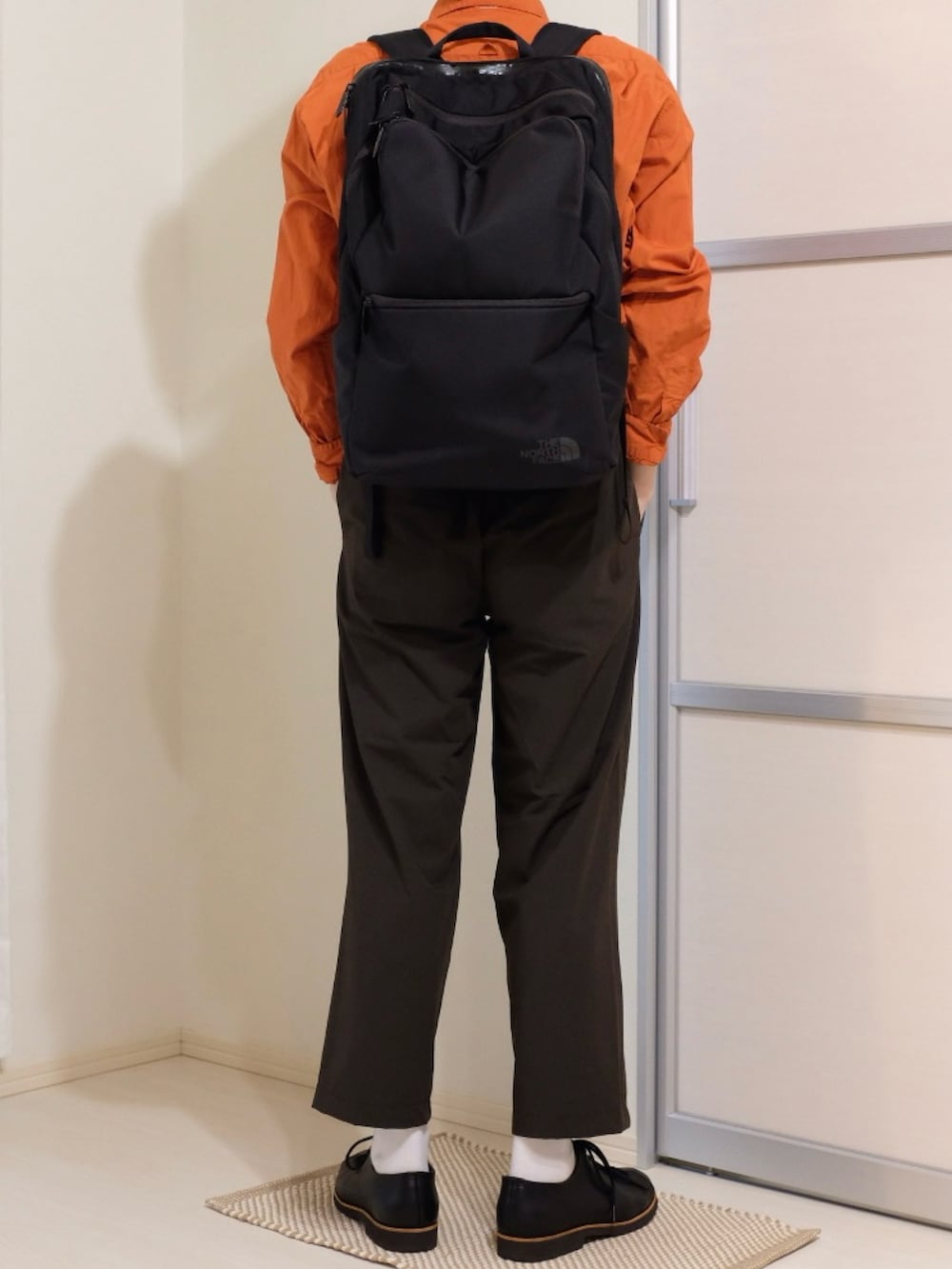 ブラウン系のその他パンツ、ブラック系のバックパック/リュック、オレンジ系のシャツ/ブラウスを着用したメンズの秋コーディネートの4枚目の写真