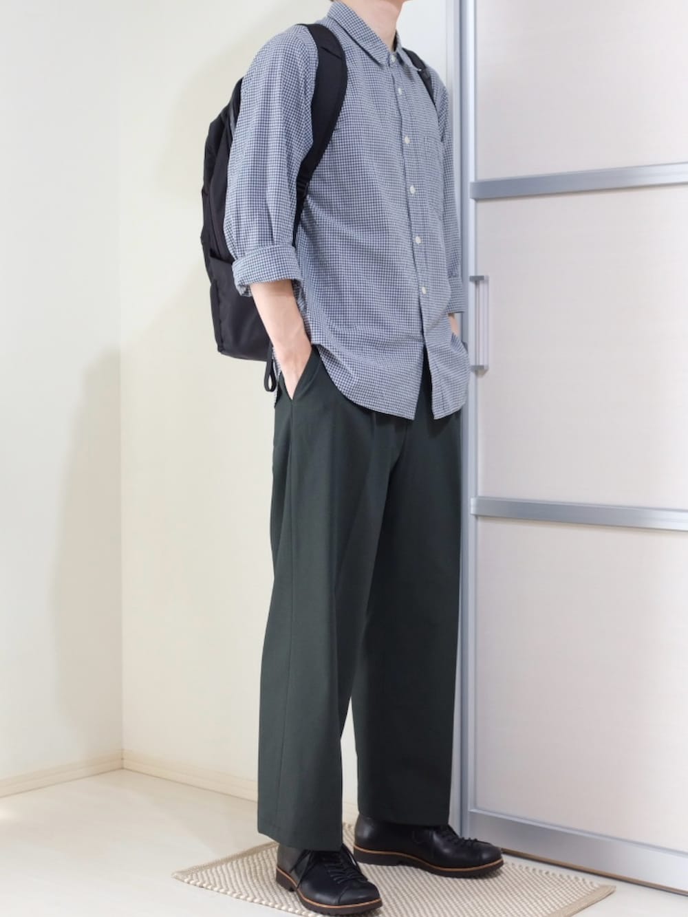 ブラック系のバックパック/リュック、グリーン系のパンツ、ブラック系のドレスシューズを着用したメンズの秋コーディネートの4枚目の写真