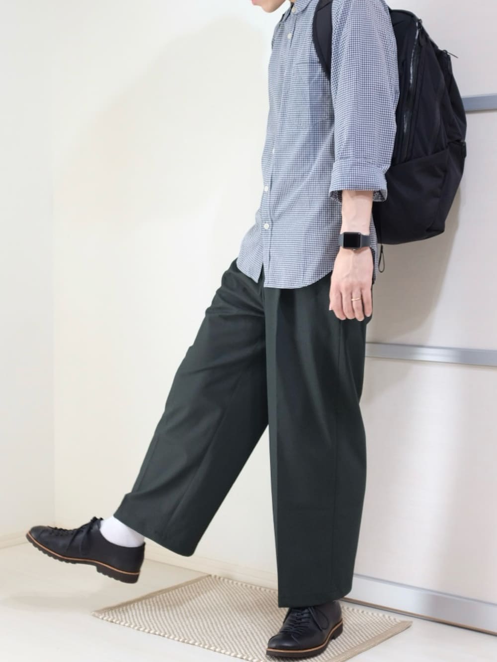 ブラック系のバックパック/リュック、グリーン系のパンツ、ブラック系のドレスシューズを着用したメンズの秋コーディネートの5枚目の写真