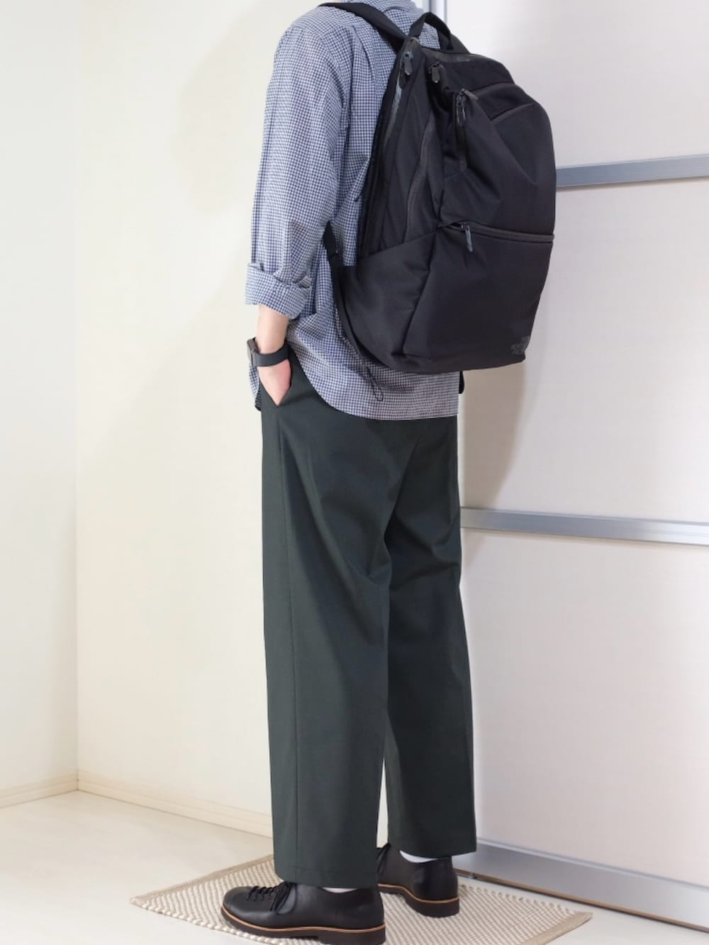 ブラック系のバックパック/リュック、グリーン系のパンツ、ブラック系のドレスシューズを着用したメンズの秋コーディネートの2枚目の写真