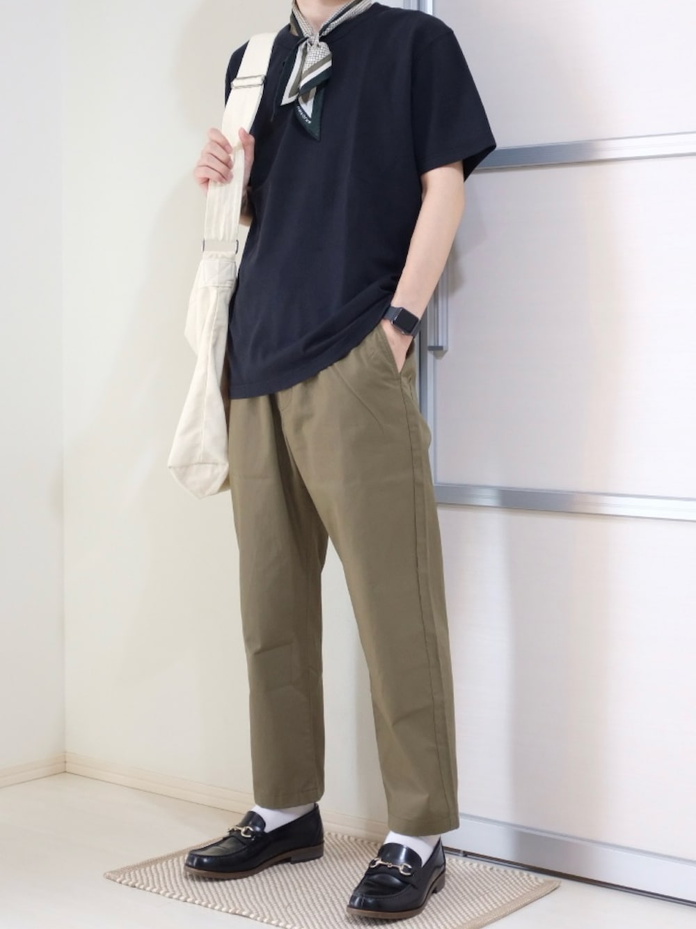 ベージュ系のショルダーバッグ、ブラック系のTシャツ/カットソー、ブラック系のローファーを着用したメンズの秋コーディネートの3枚目の写真