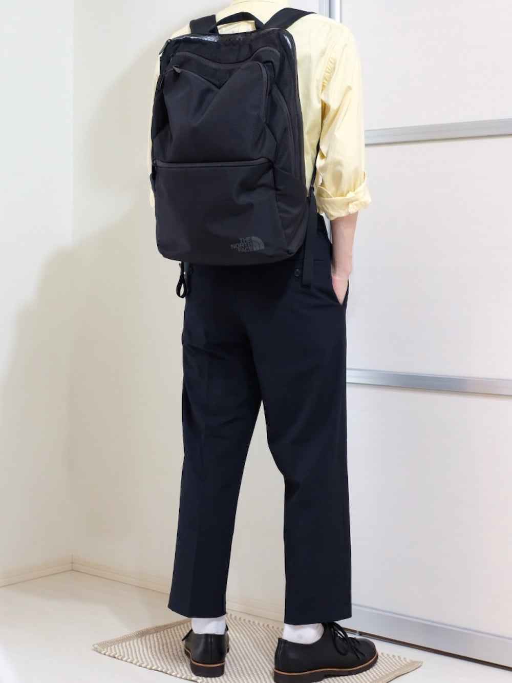 ブラック系のドレスシューズ、ブルー系のパンツ、イエロー系のシャツ/ブラウスを着用したメンズの秋コーディネートの3枚目の写真