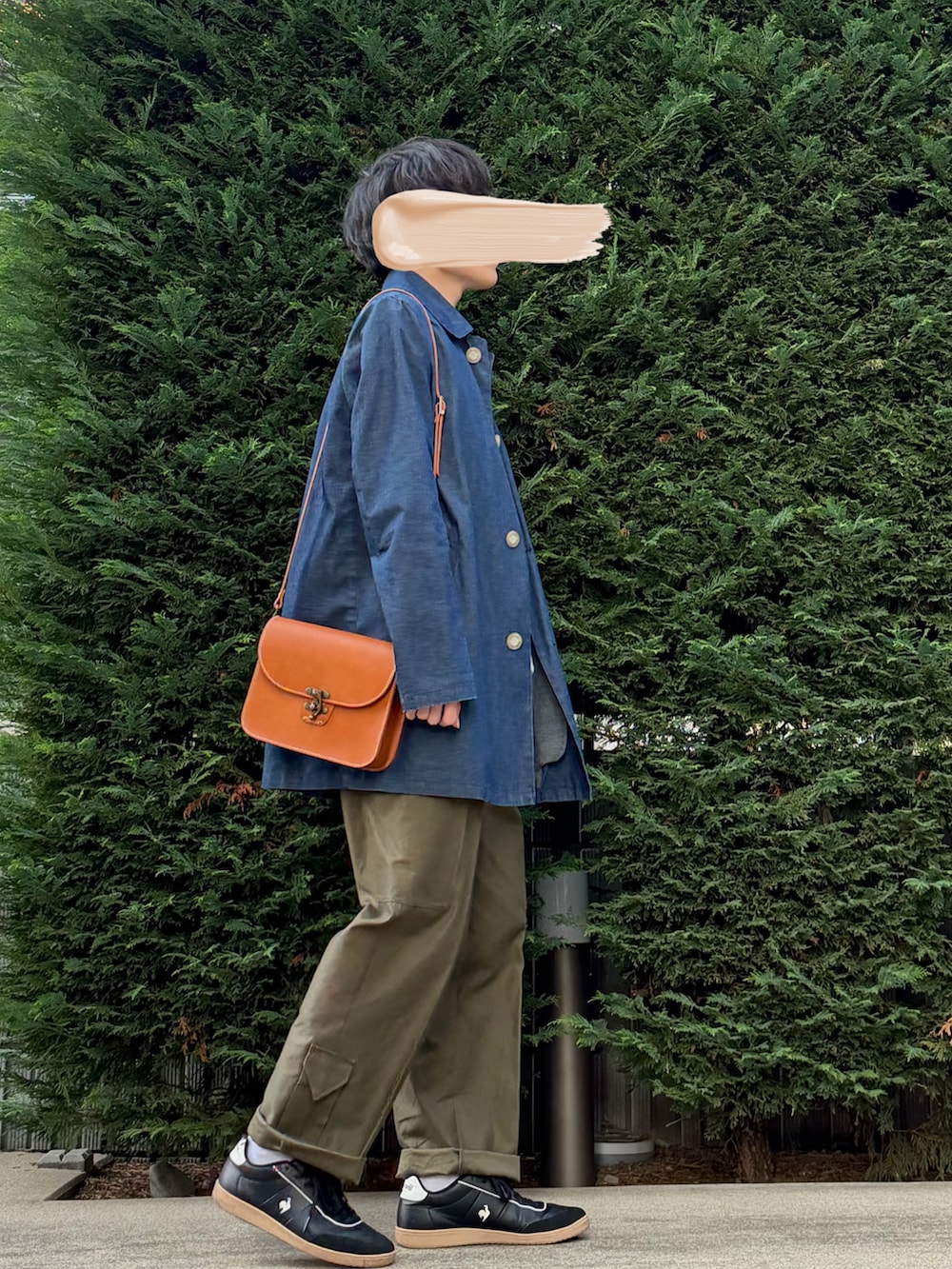 ベージュ系のベスト、ブルー系のその他アウター、オレンジ系のショルダーバッグを着用したメンズの秋コーディネートの2枚目の写真