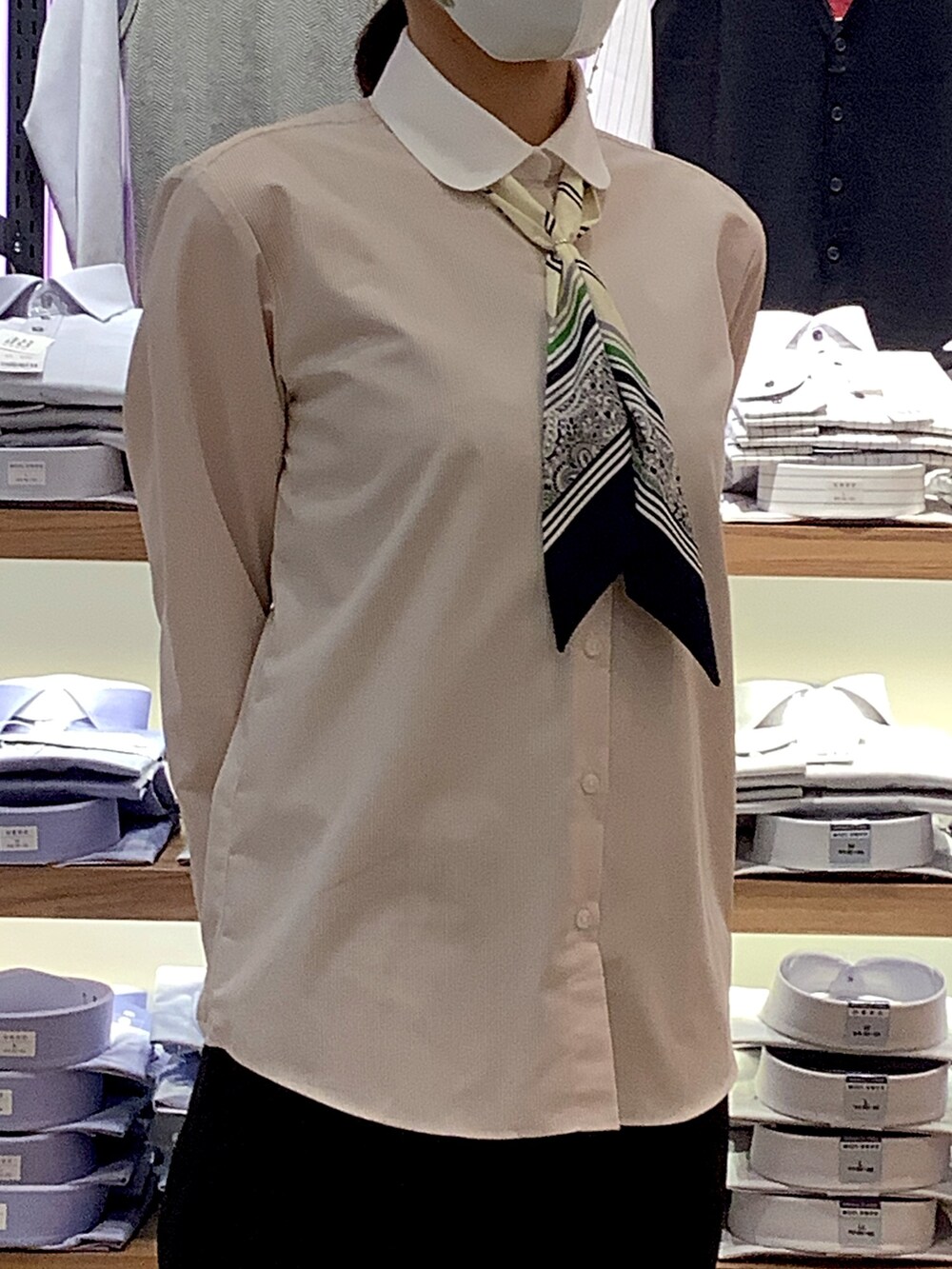 ベージュ系のビジネスシャツ、ブルー系のバンダナ/スカーフを着用したレディースの冬コーディネートの2枚目の写真