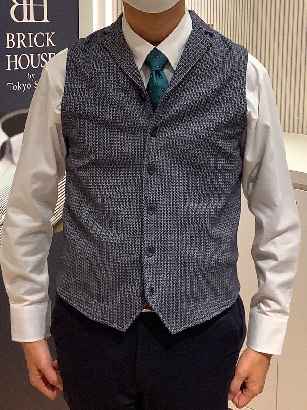 ホワイト系のビジネスシャツ、ブルー系のネクタイ、ブルー系のベストを着用したメンズの冬コーディネートの2枚目の写真