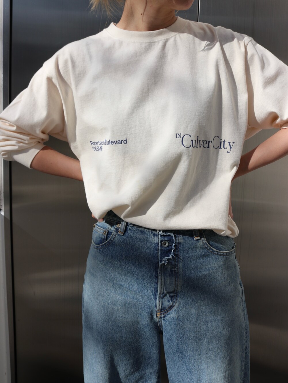 ホワイト系のTシャツ/カットソー、ブルー系のデニムパンツ、イエロー系のトートバッグを着用したレディースの春コーディネートの5枚目の写真