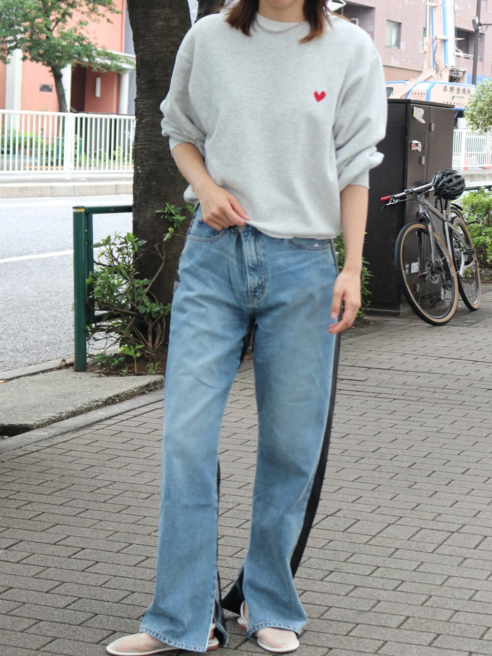 グレー系のスウェット、ブルー系のデニムパンツを着用したレディースの夏コーディネートの2枚目の写真