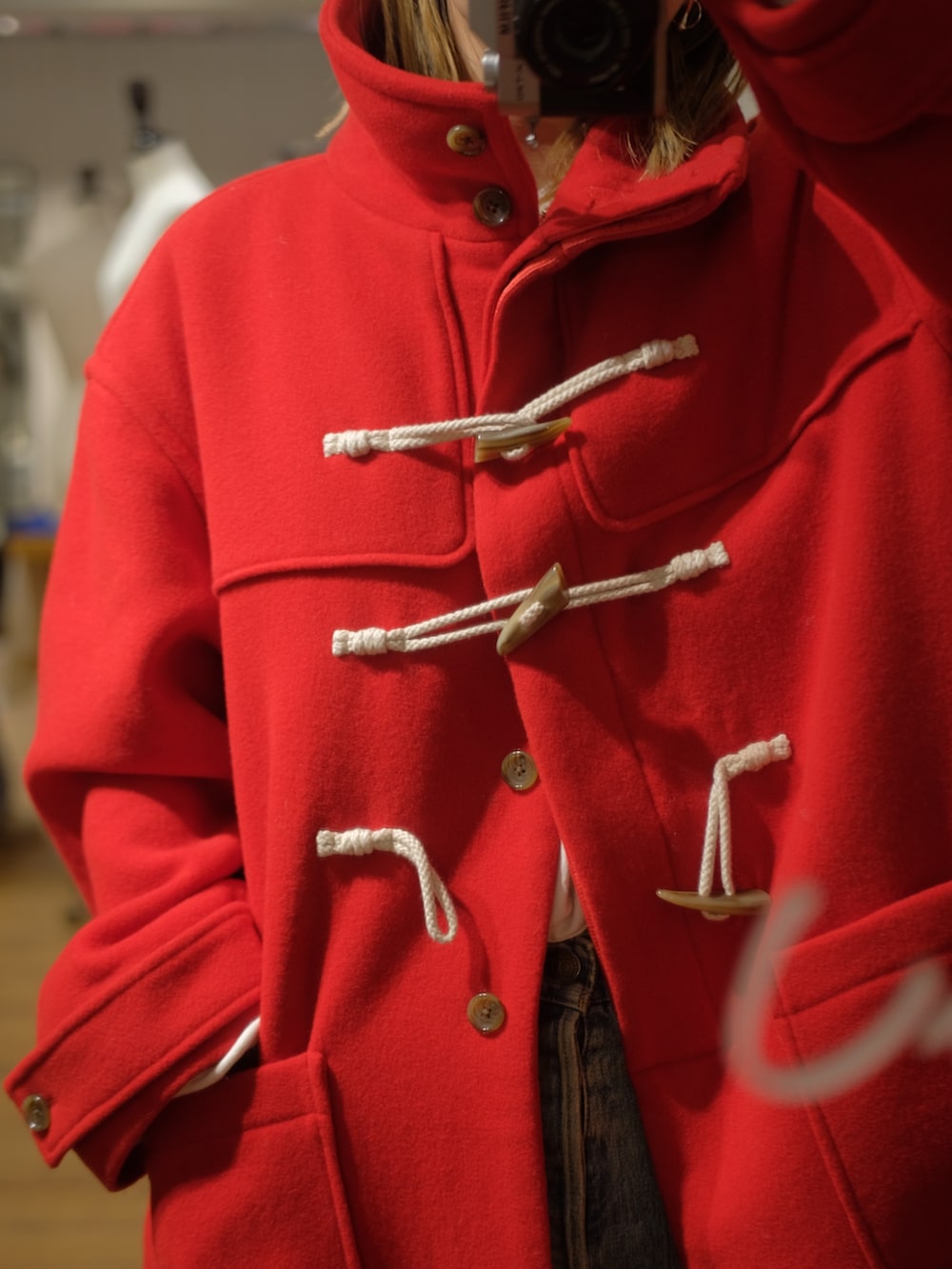 レッド系のダッフルコートを着用したレディースの秋コーディネートの3枚目の写真