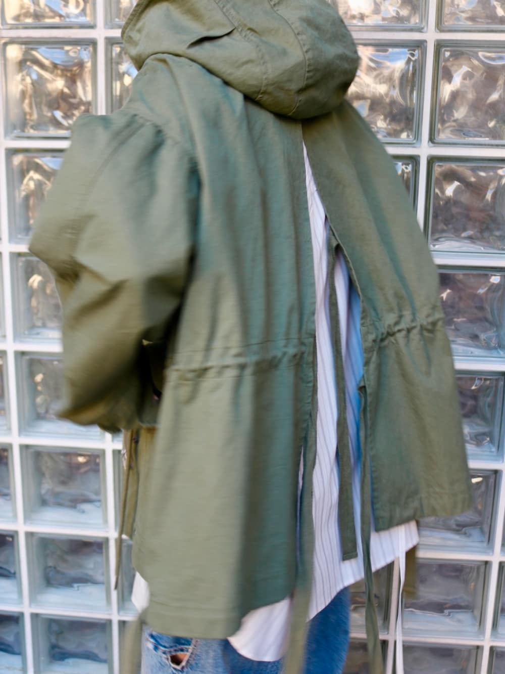 ブルー系のデニムパンツ、ホワイト系のシャツ/ブラウス、グリーン系のその他アウターを着用したレディースの冬コーディネートの3枚目の写真