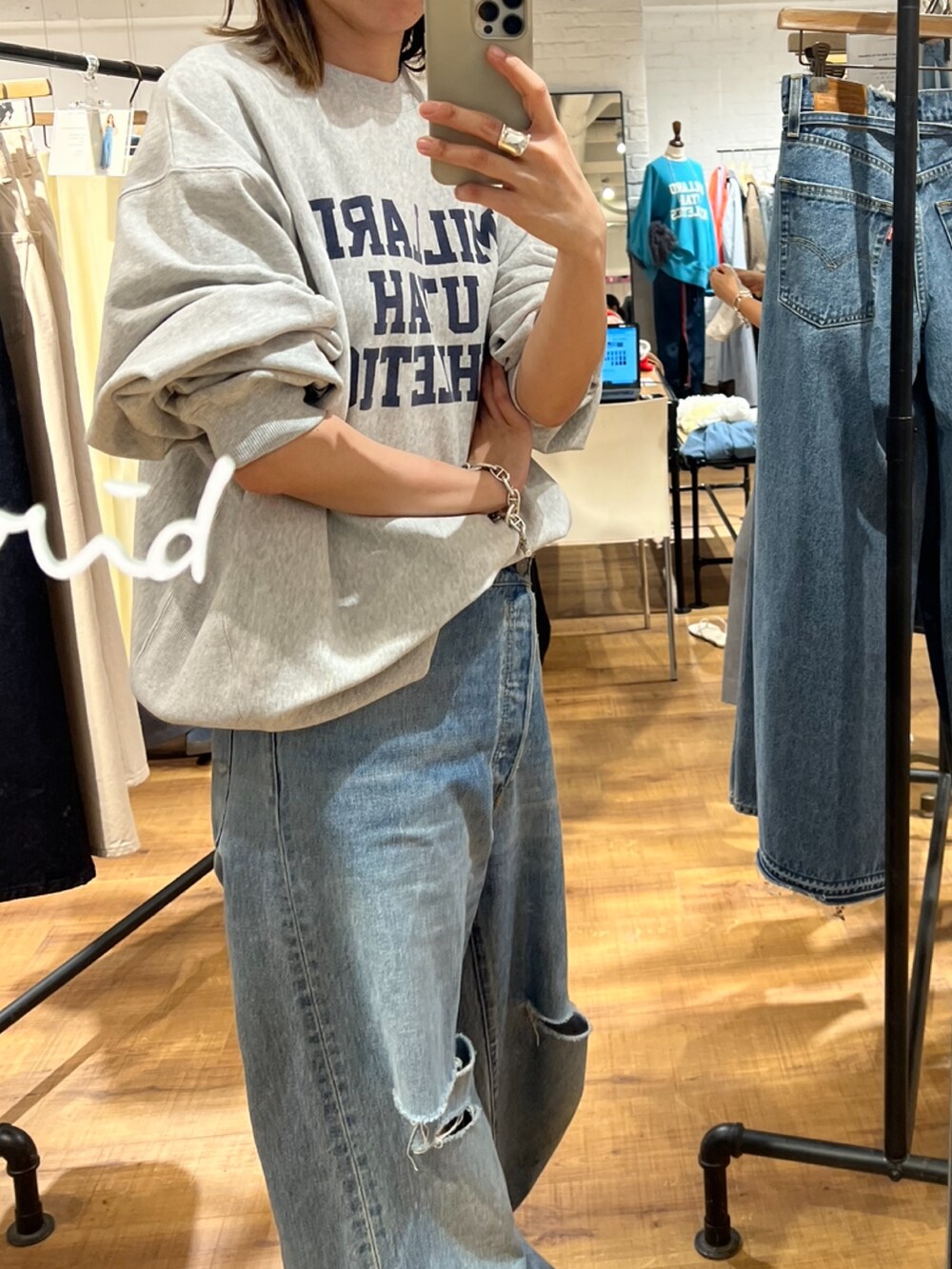 グレー系のスウェット、ブルー系のデニムパンツを着用したレディースの秋コーディネートの2枚目の写真